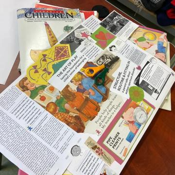 Early childhood teaching resources spread across a table, including an issue of the journal Canadian Children and a handmade collage about the art of play.