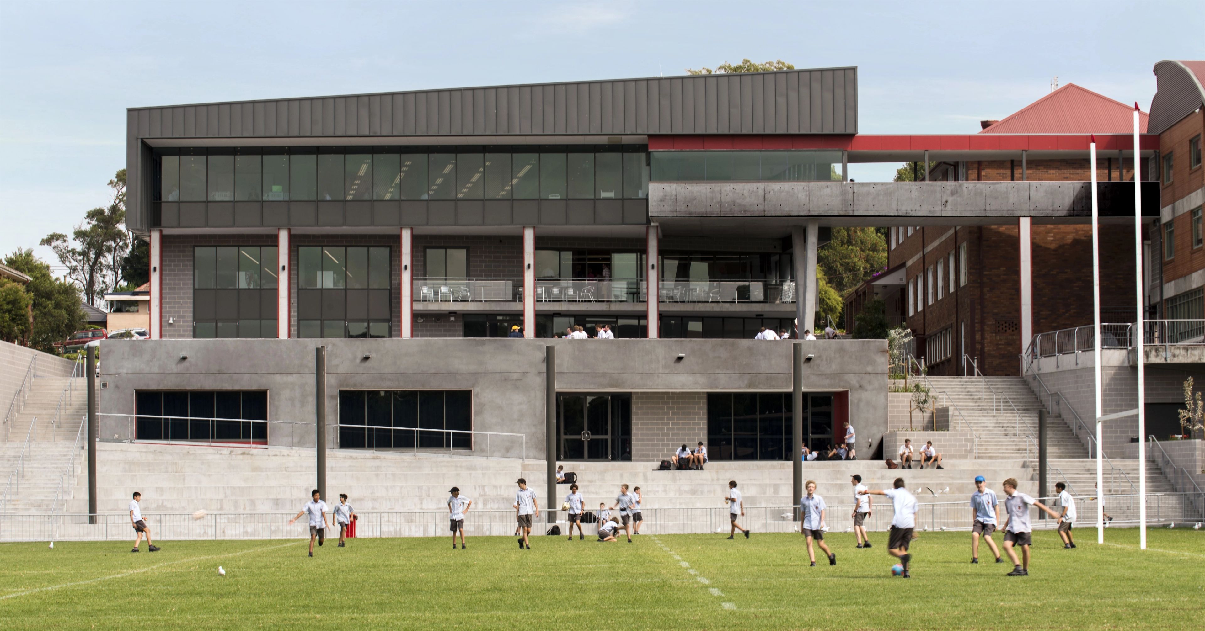 Students on the playing field in front of the Brother Shanahan Learning Centre at St Edward's College, showcasing contemporary educational architecture.