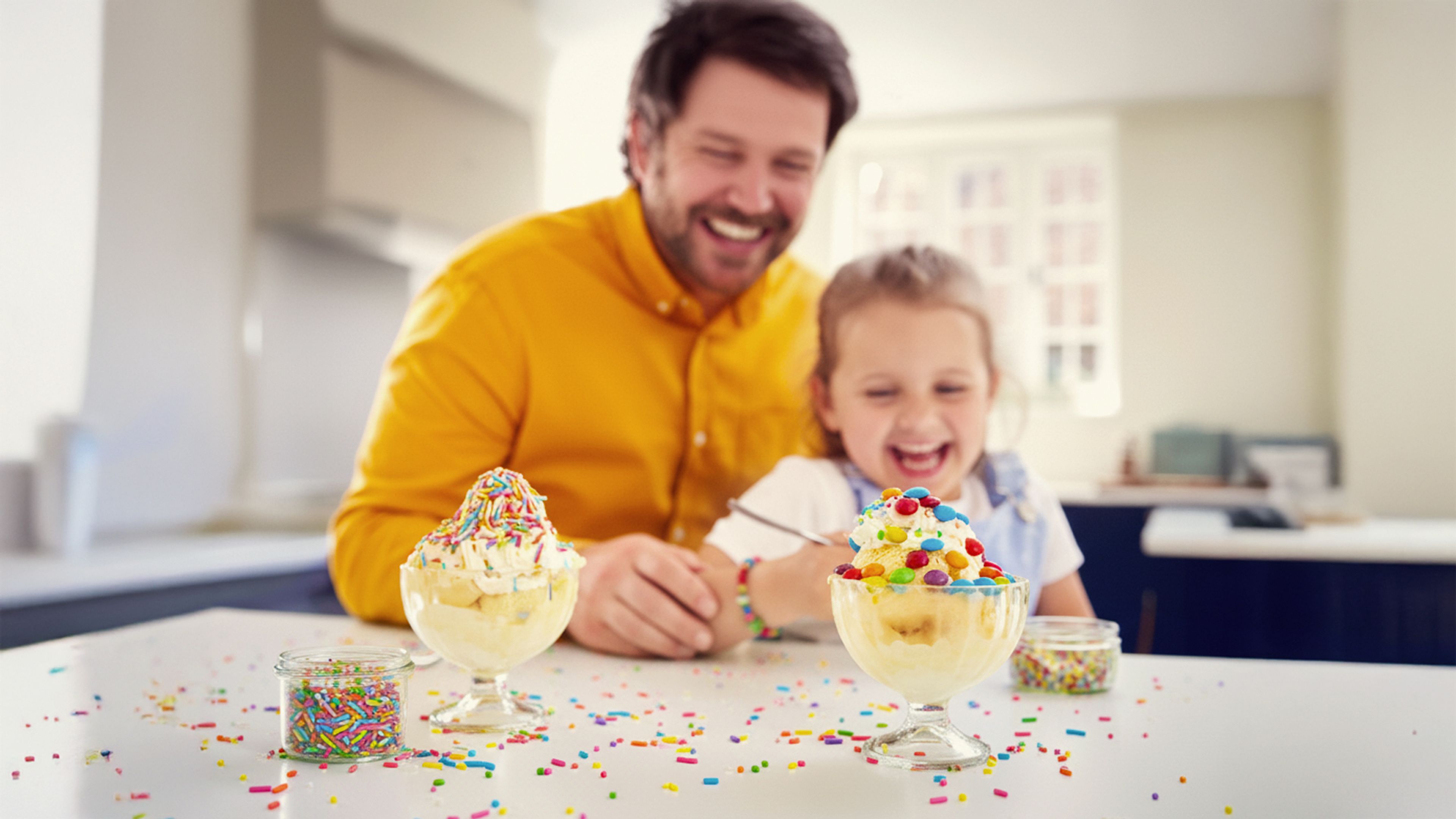 Bilde av far og barn som spiser Diplom-Is på hjemme på kjøkkenet