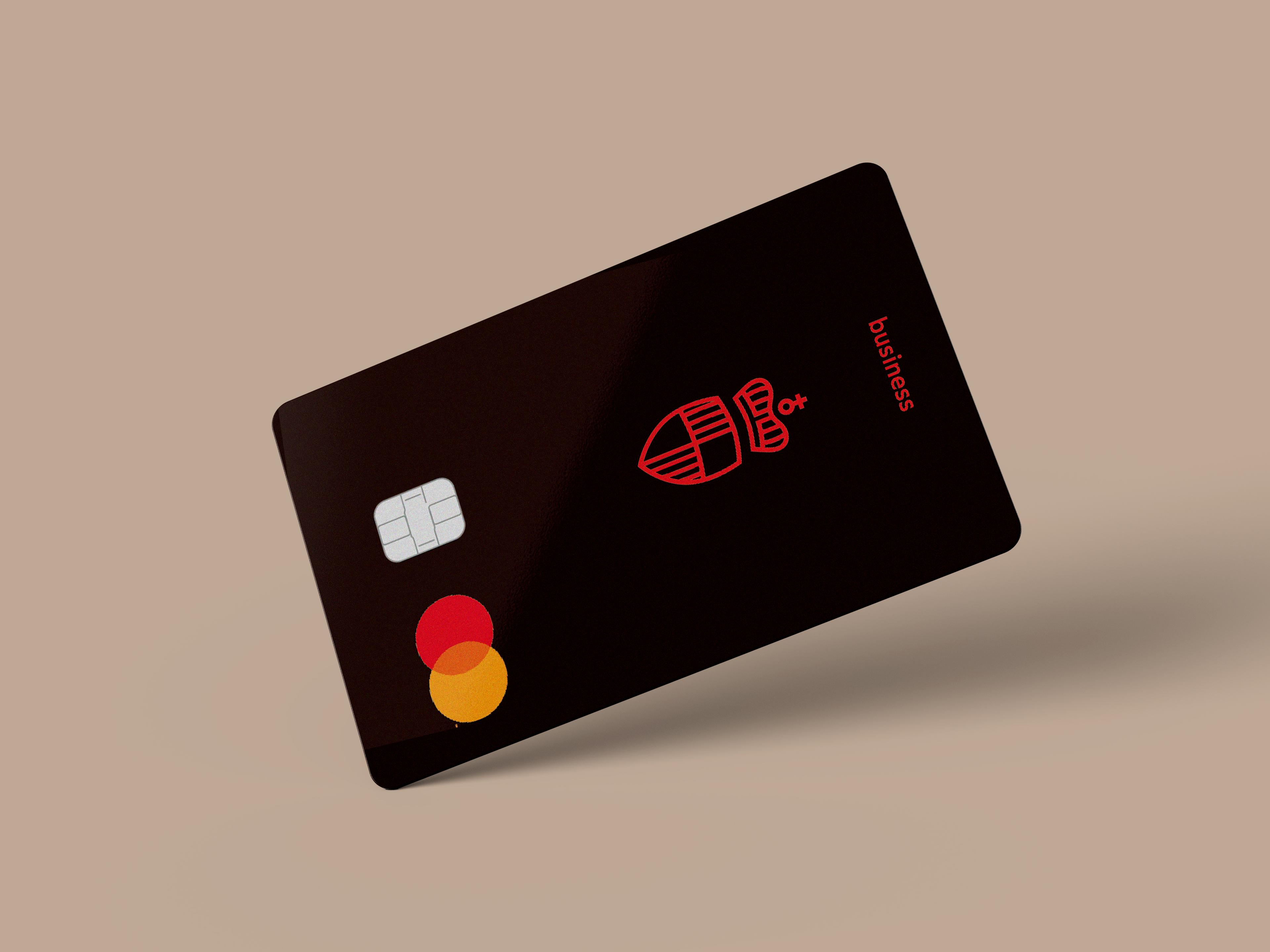 Schwarze Mastercard Business Kreditkarte mit rotem Wappen und Chip auf beigem Hintergrund