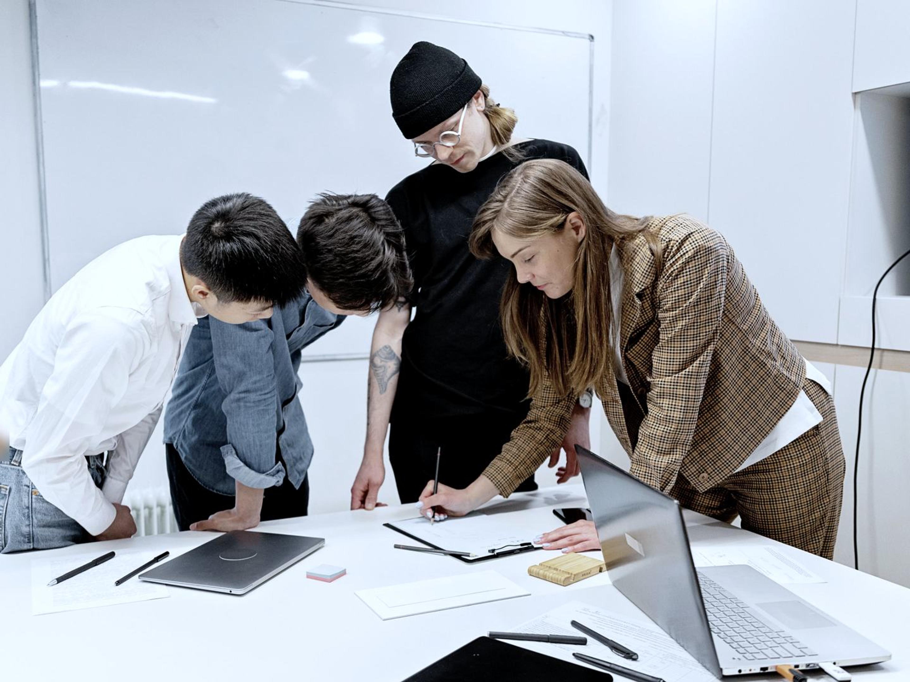 A team discussing a project around a white table in a bright office