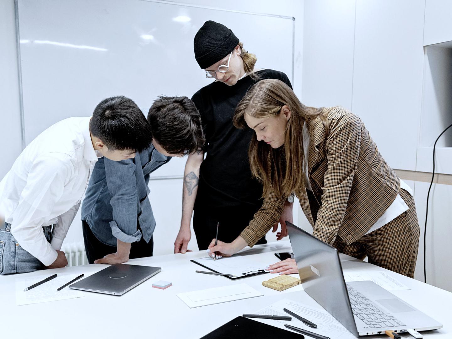 A team discussing a project around a white table in a bright office