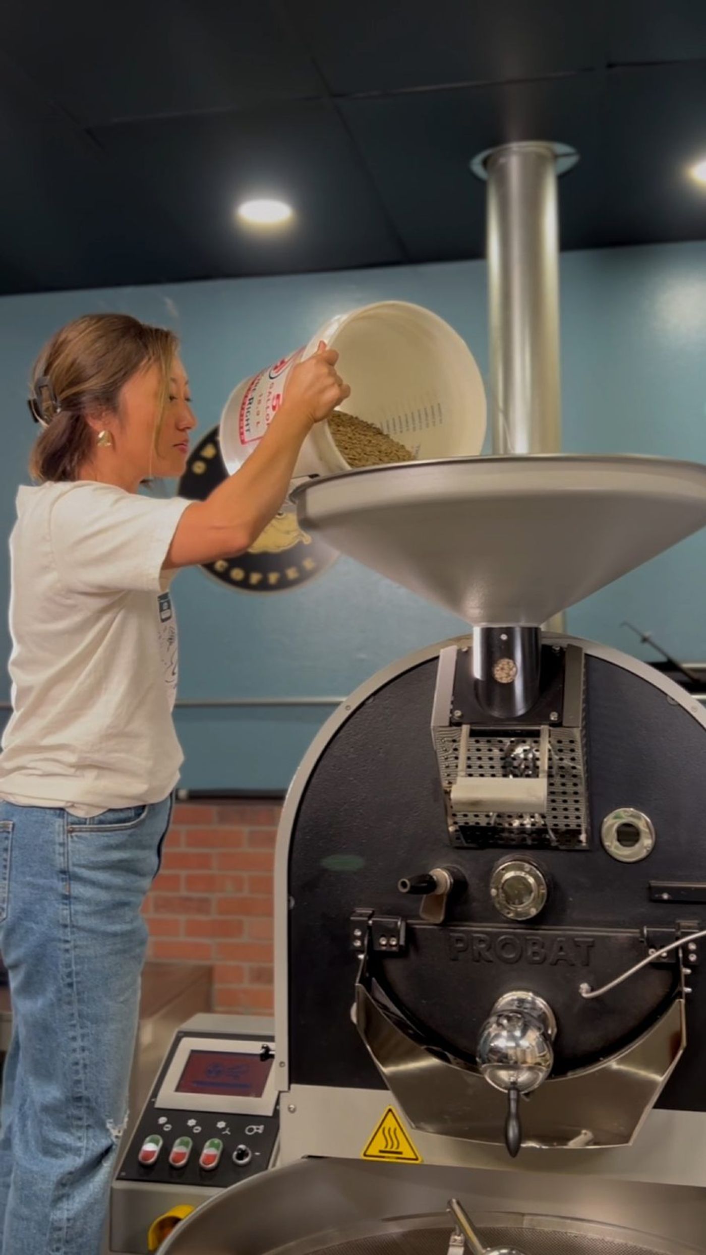 Pouring green coffee beans into the roaster