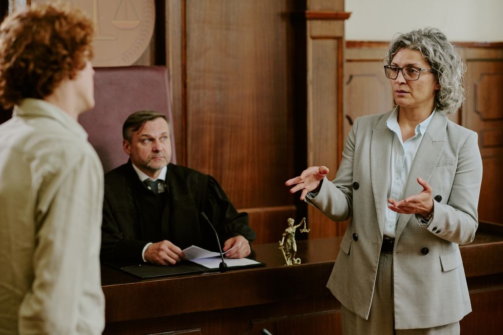 Defense attorney speaking in a courtroom during a fake ID case hearing.