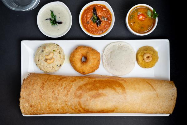 A South Indian mini tiffin platter featuring assorted breakfast favorites served with chutneys and sambar.