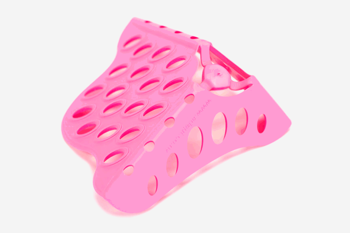 Pink Beautyblender tool drying stand with numerous oval holes.