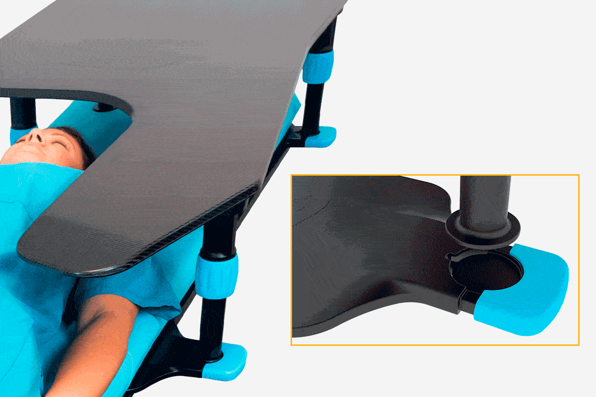 Patient on a medical bed with a U-shaped dark grey medical table positioned over their torso, supported by adjustable black and blue legs. Inset shows a leg detail.