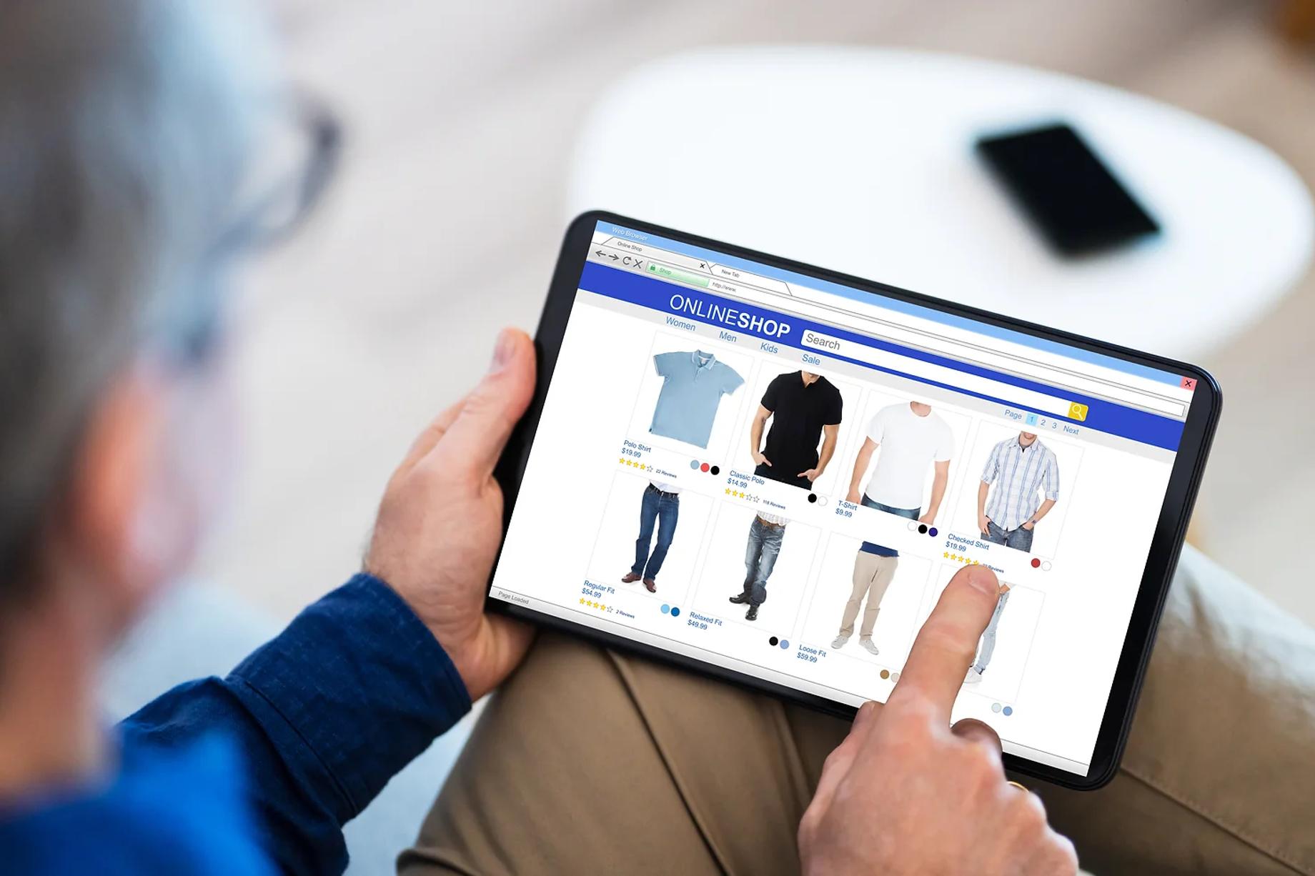 A man browsing men's wear on a tablet