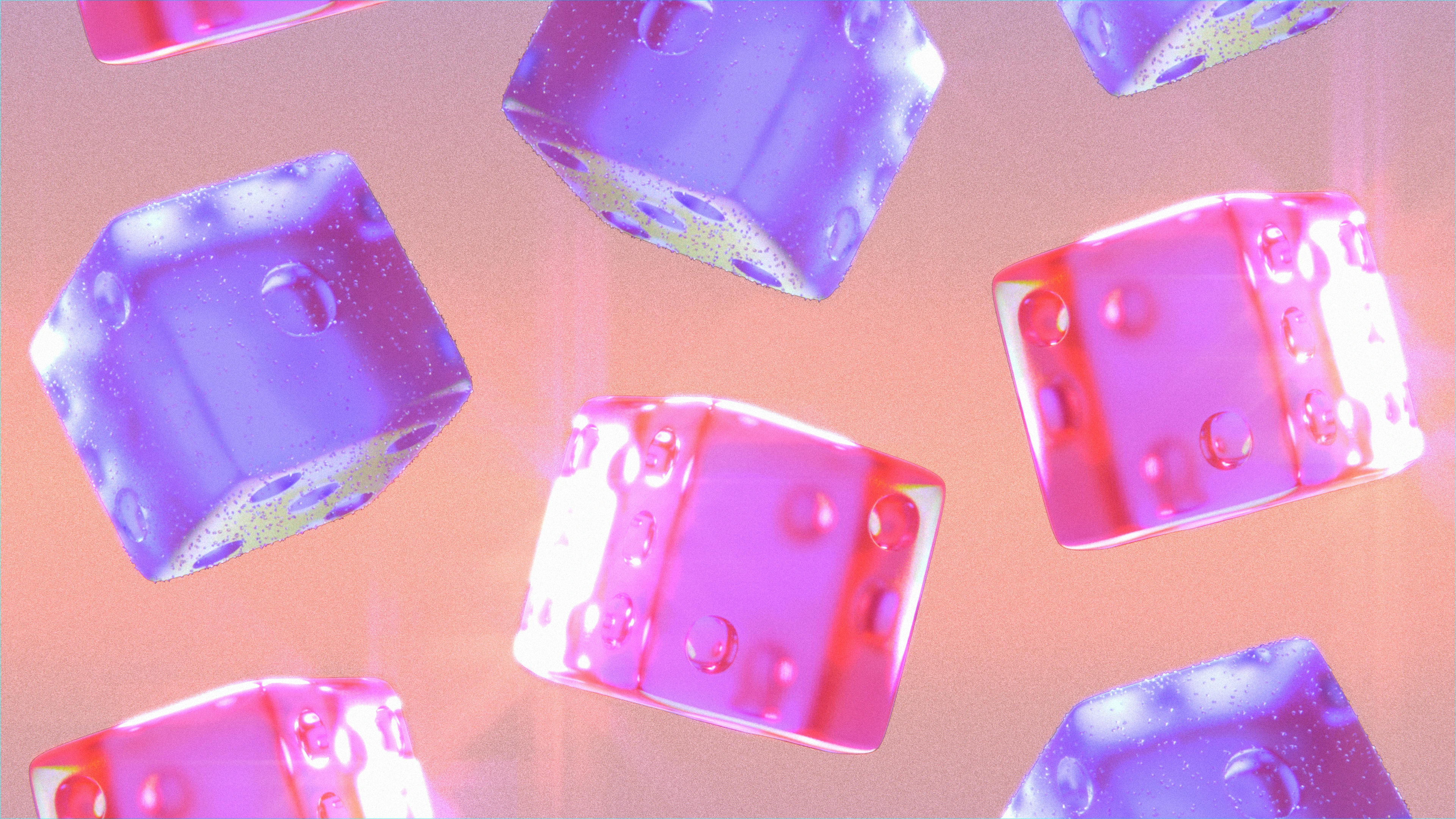 Close-up glass dices in pink and purple with light refracting off