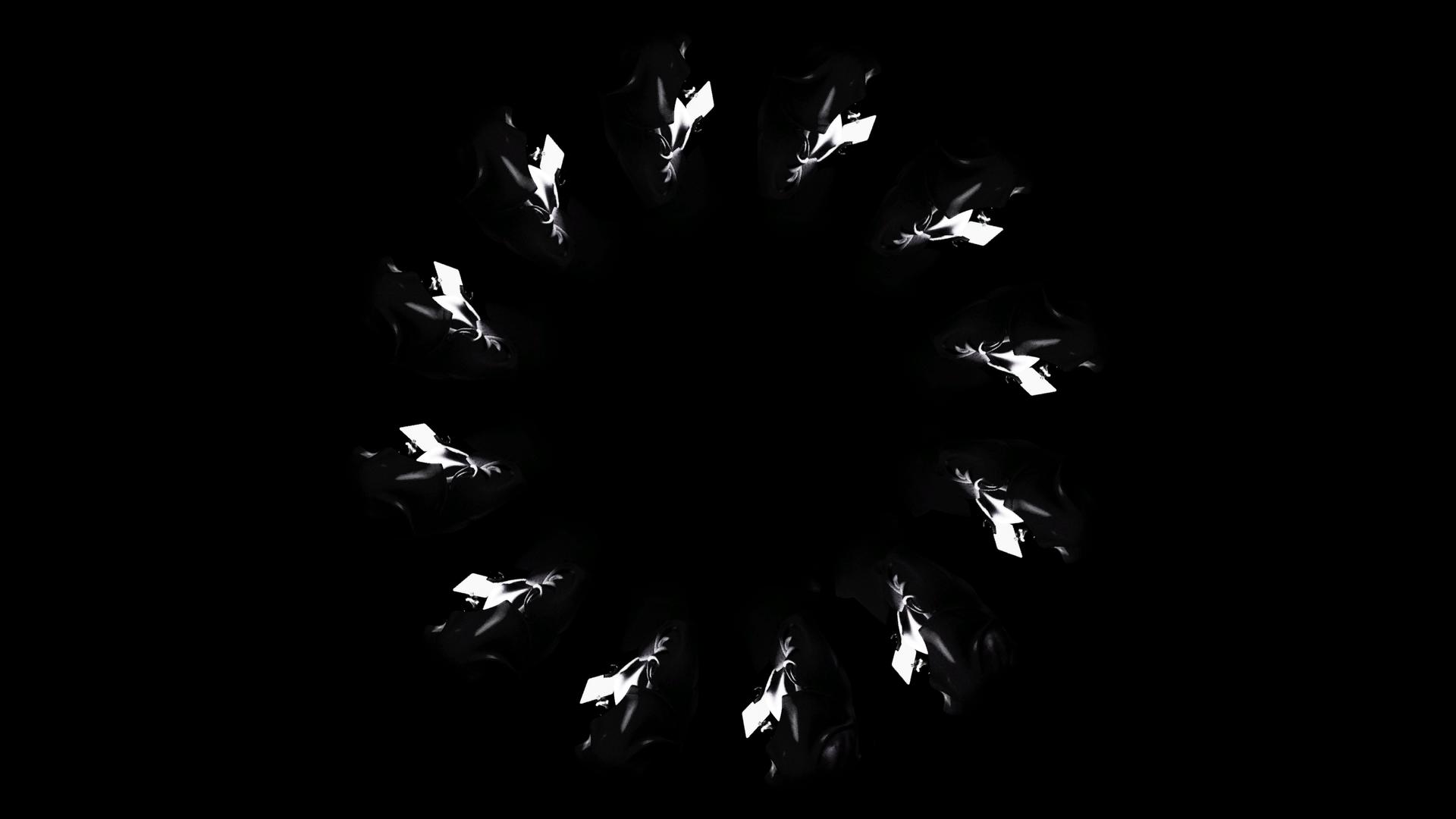Overhead shot of cloaked figures walking in a circle