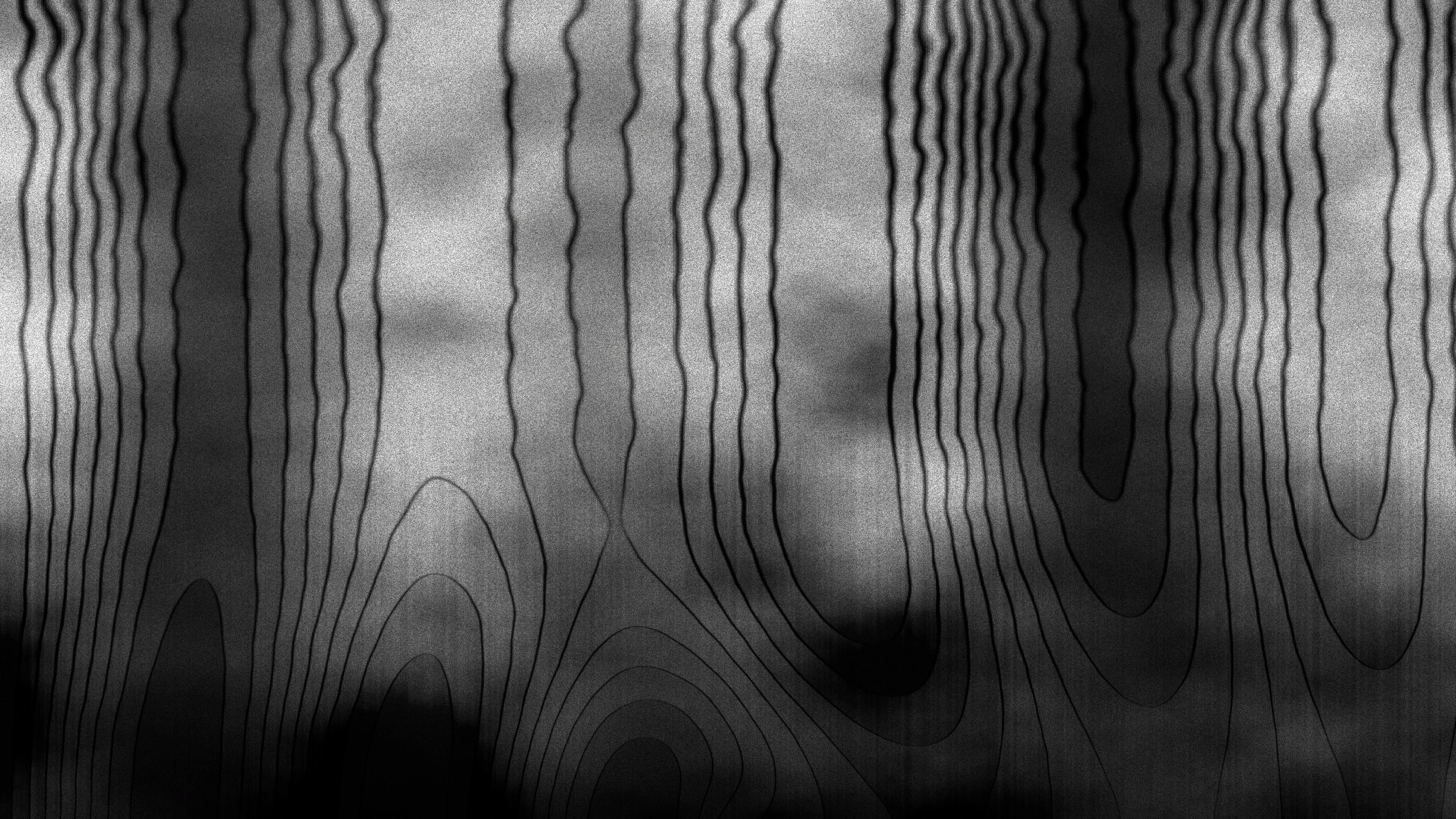 Black wavy lines drawn against a wrinkled grey paper texture