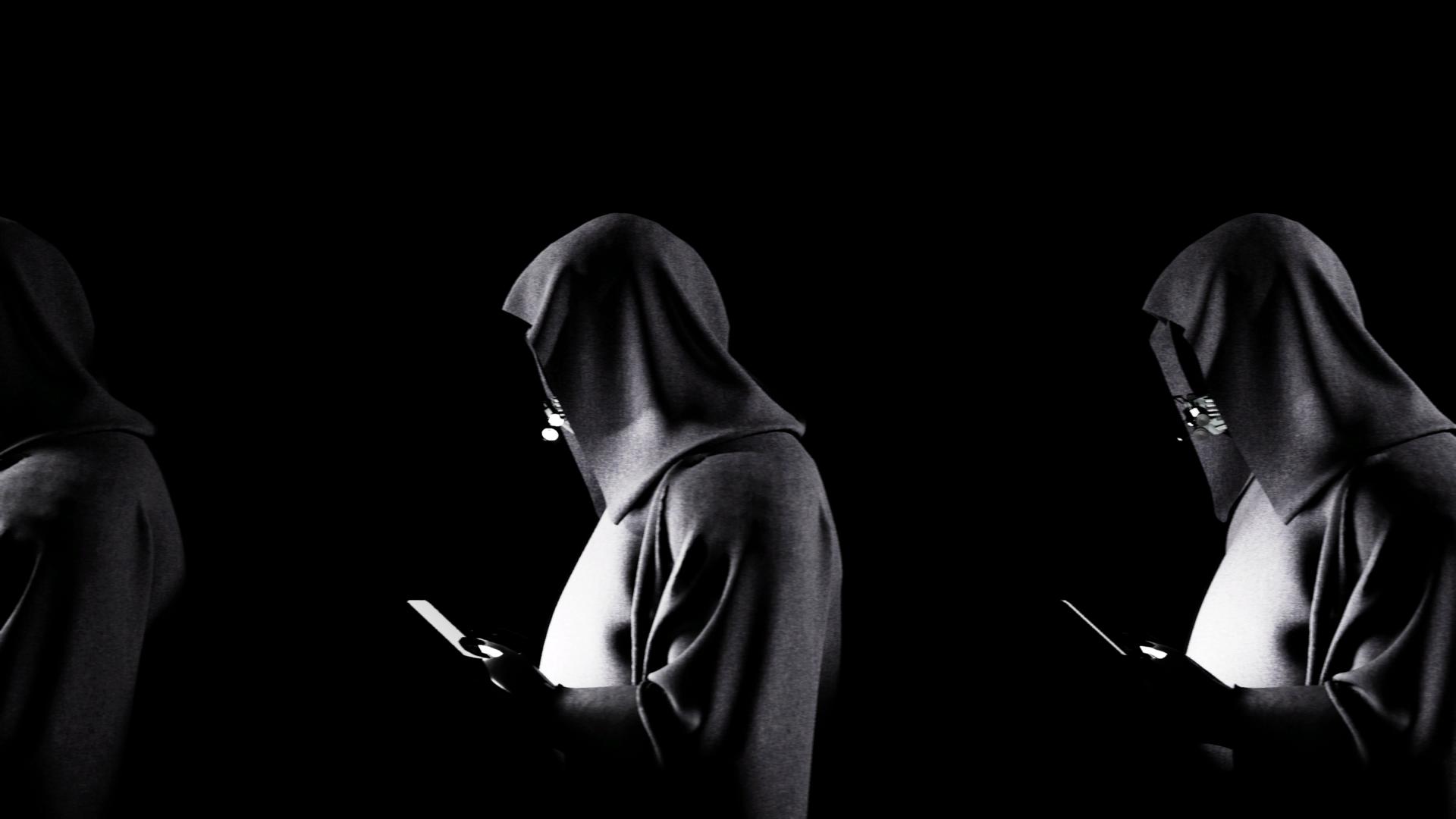 Hooded and cloaked figures looking at phones in hands walking in front of one another