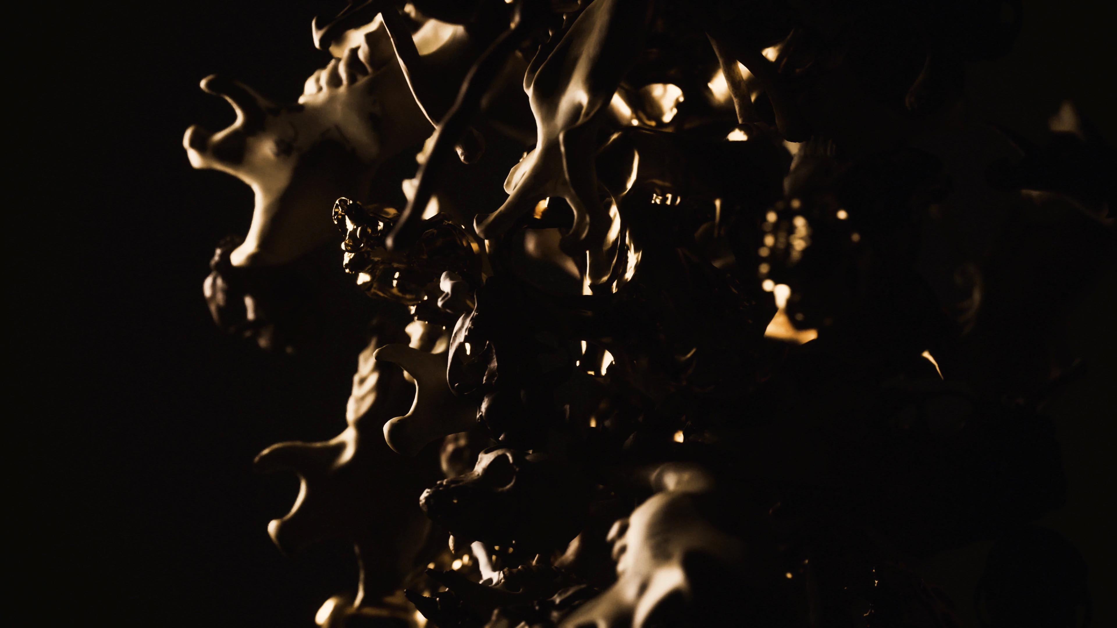 Cluster of dark orange bones reflecting some light and falling down
