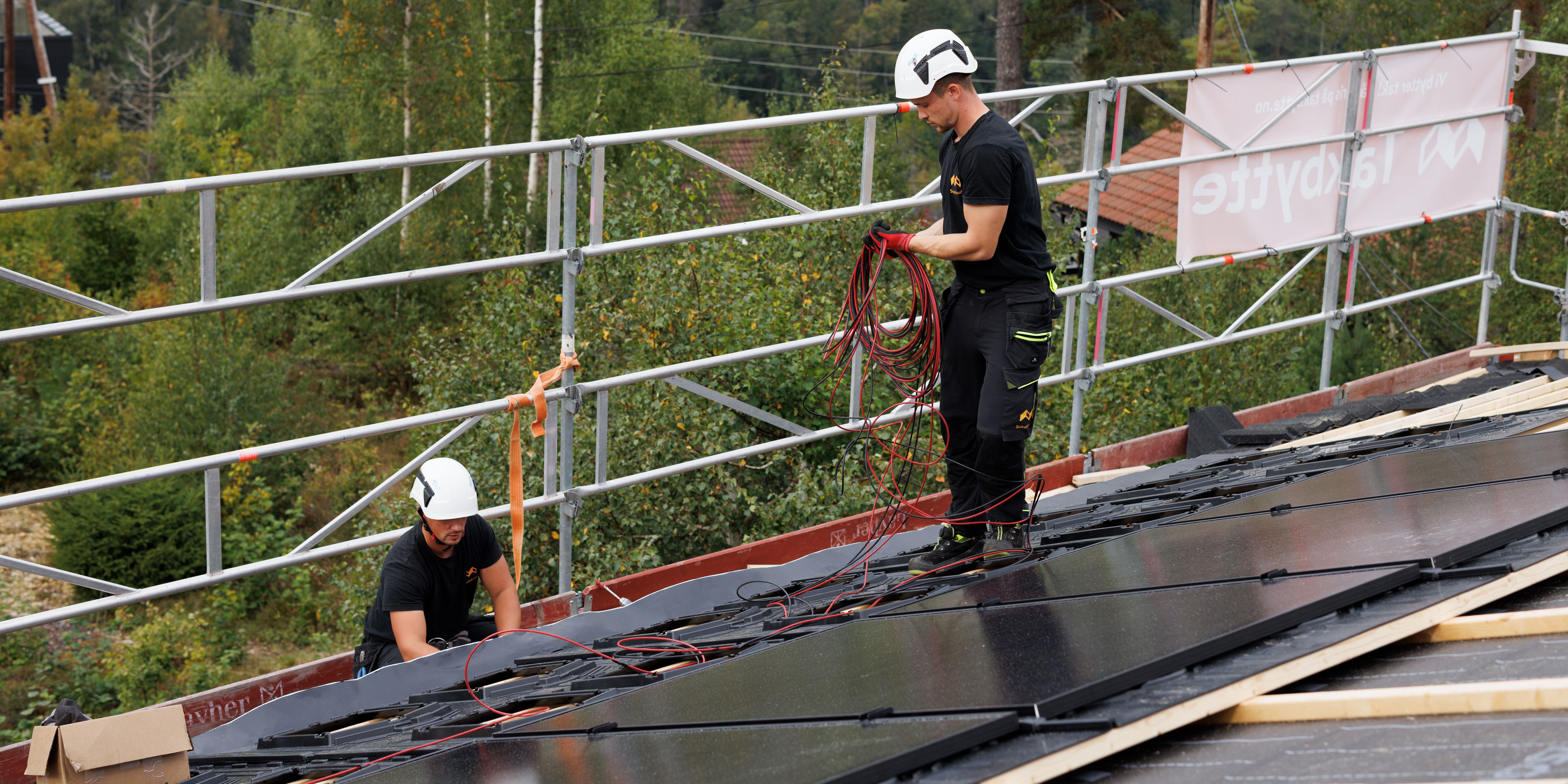 Kvalifiserte montører i Solcellekraft jobber med kabling av solceller 