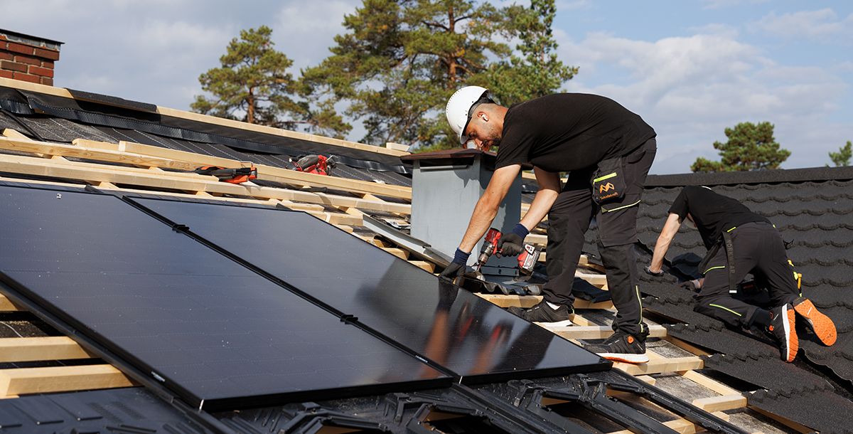 Montører installerer solceller på taket for egenbredskap 