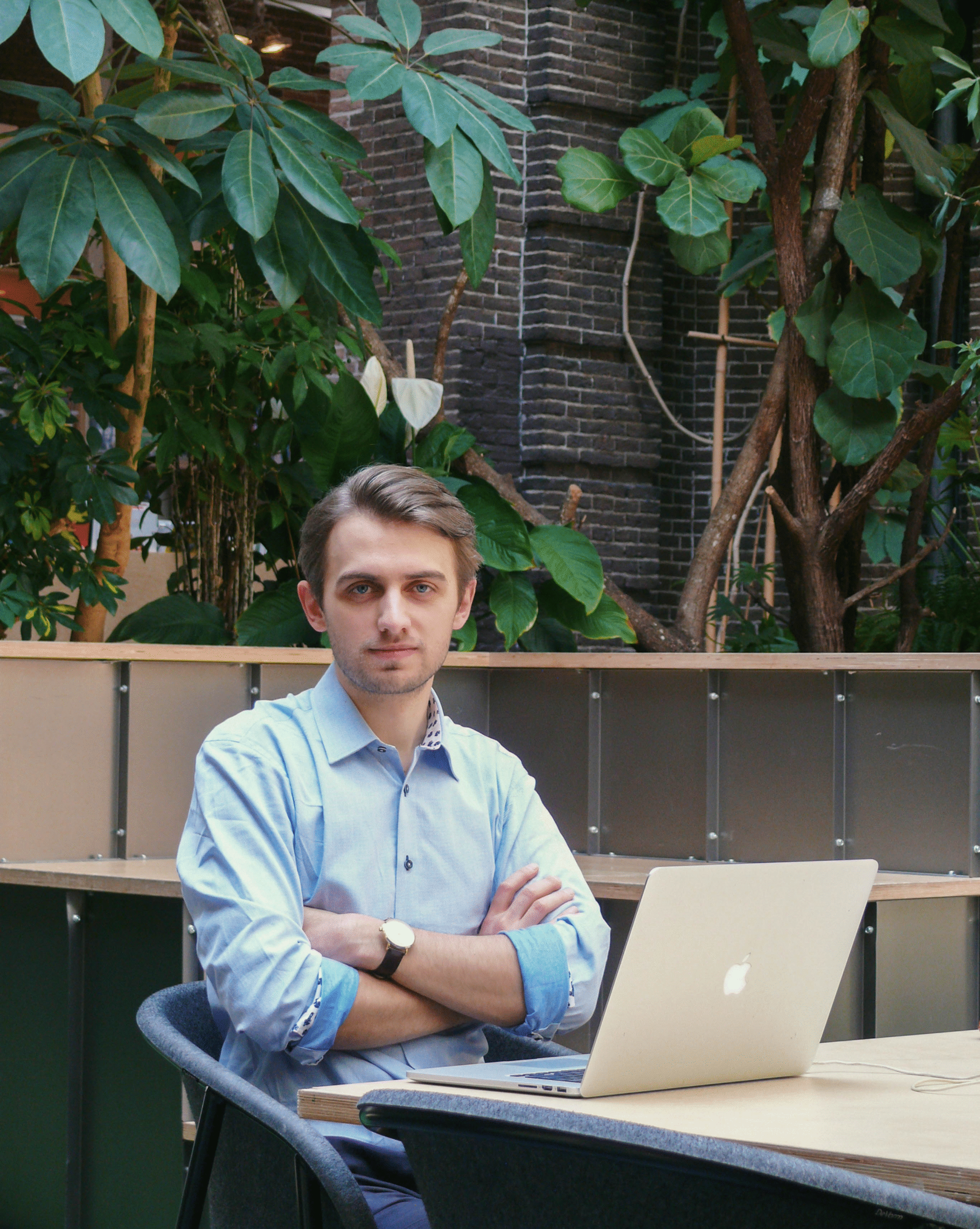 Borys Kapica sitting at a laptop with arms crossed