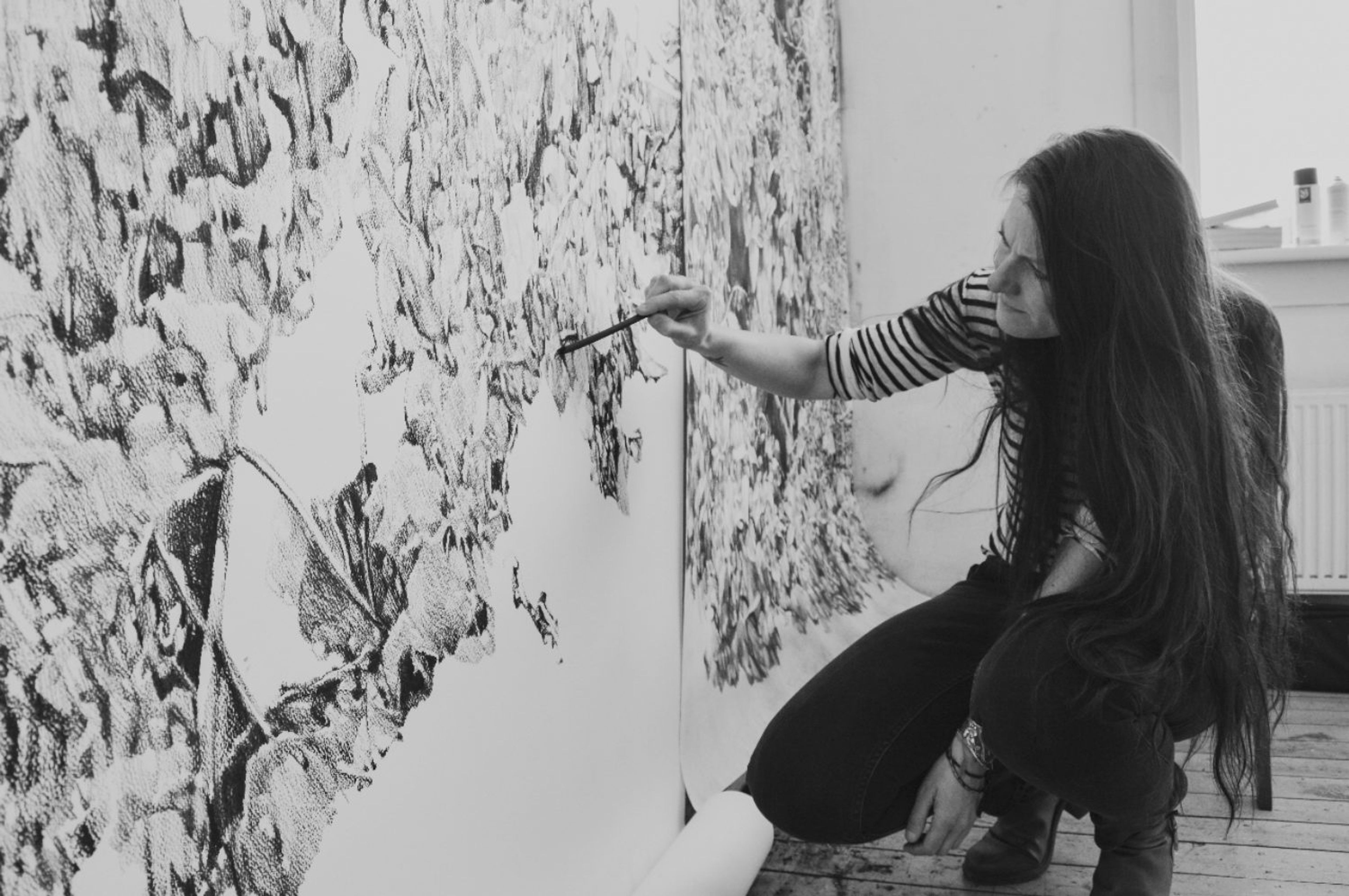Foto van kunstenaar Anouk Griffioen terwijl ze werkt aan een houtskooltekening