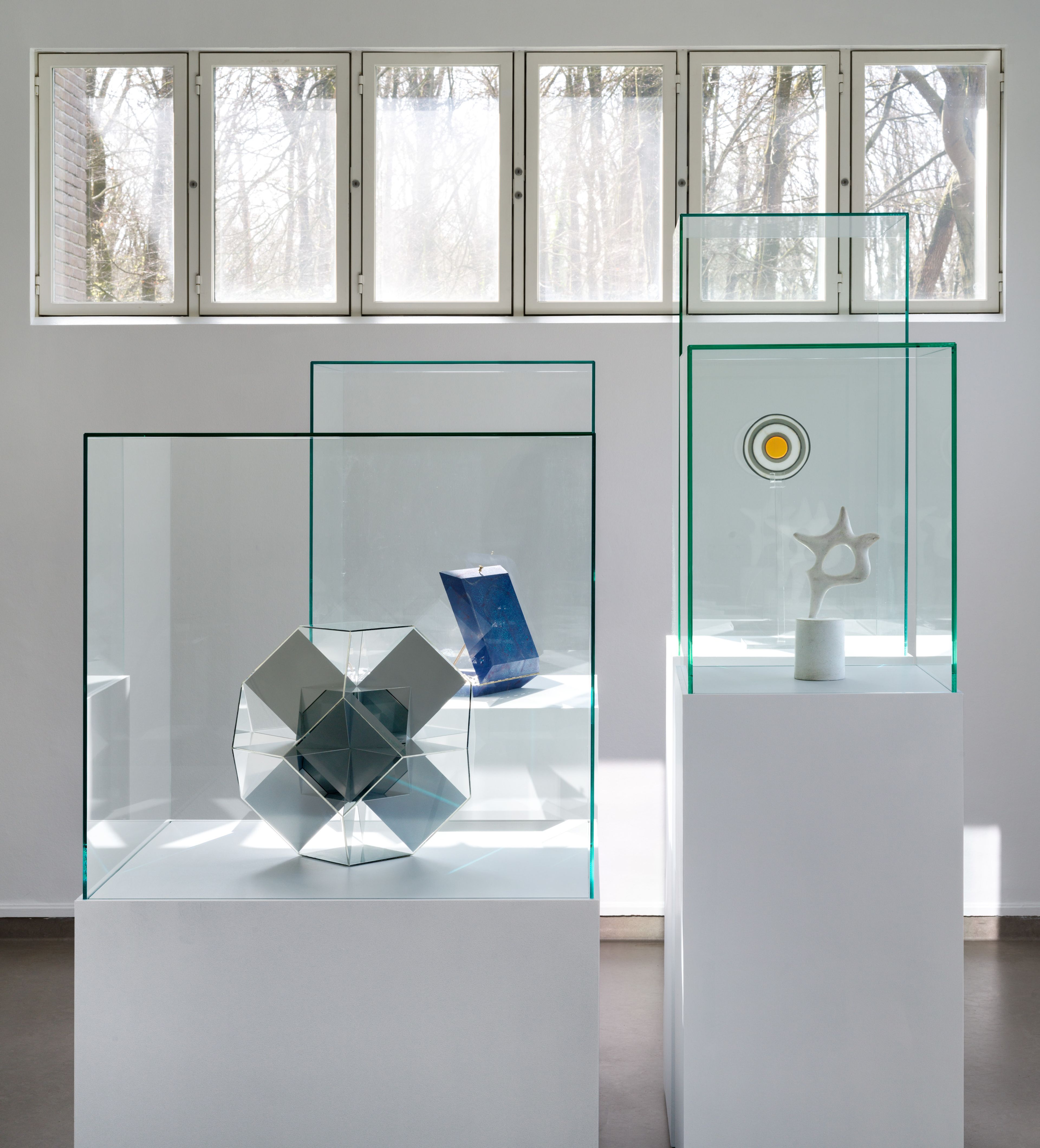 Zaaloverzicht tentoonstelling Ruimtereis Foto van de tentoonstelling in het museum met twee glazen vitrines op witte sokkel
