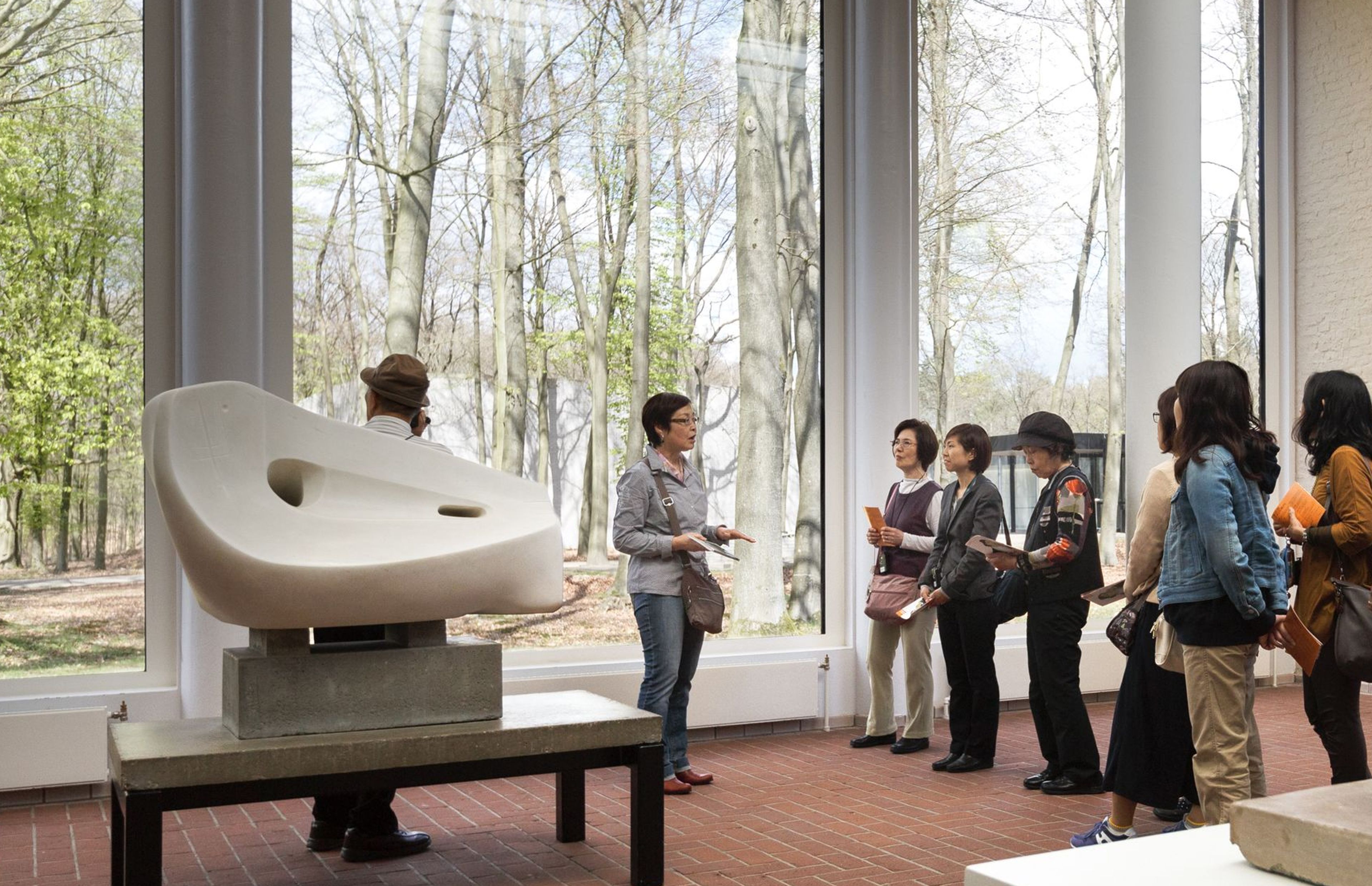 A tour operator group receives a guided tour in the museum’s sculpture gallery.