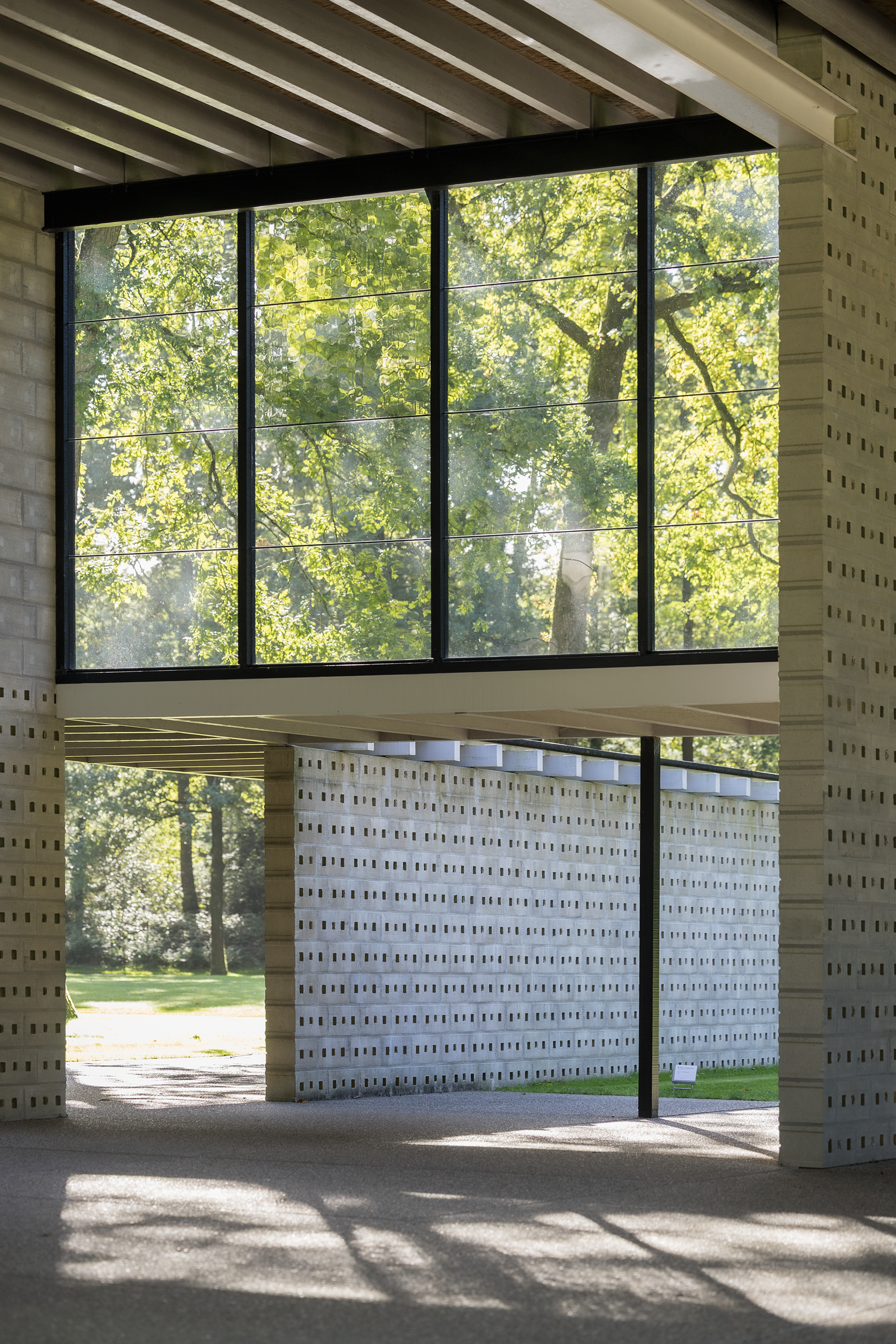 Gerrit Rietveld, _Rietveldpaviljoen_, 1954-1955 (herbouwd in 1964-1965 en 2010) Een modern gebouw met strakke lijnen en witte bakstenen, met glazen ramen met doorkijk naar de bomen