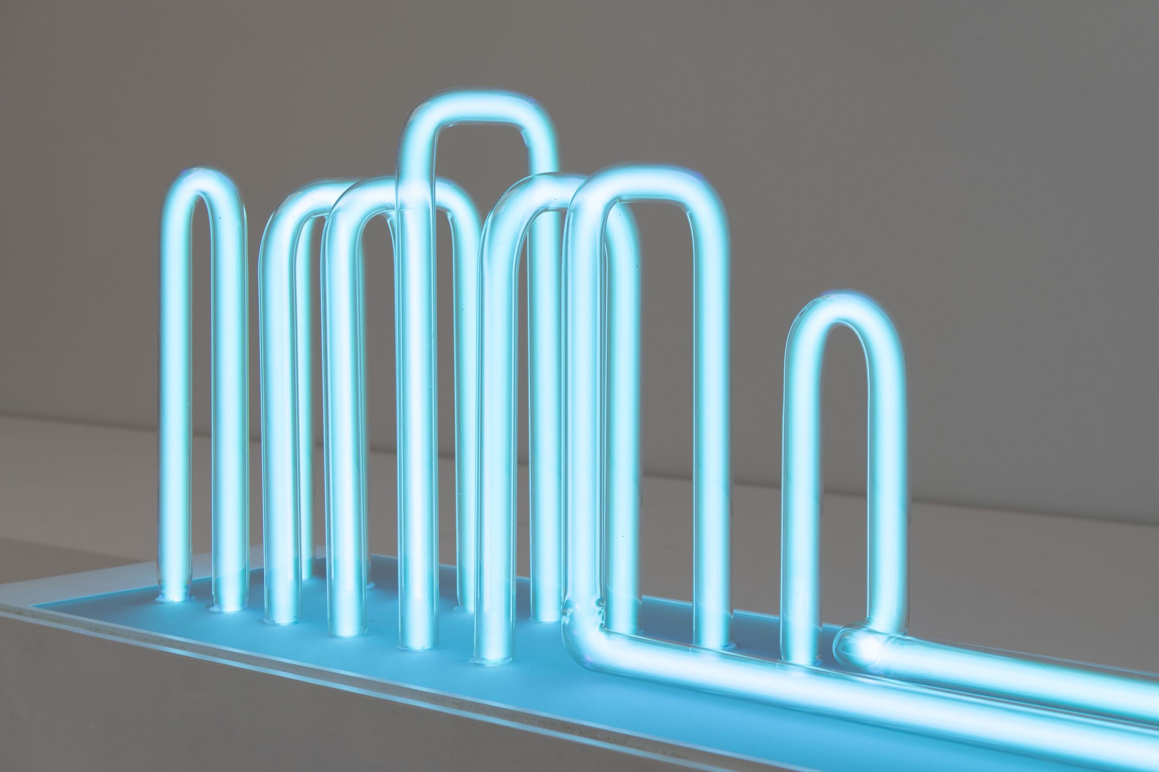 Lilian Kreutzberger. RAUFASER, 2025 Foto van een abstract neon kunstwerk met gloeiende blauwe buizen in verschillende hoogtes en vormen.