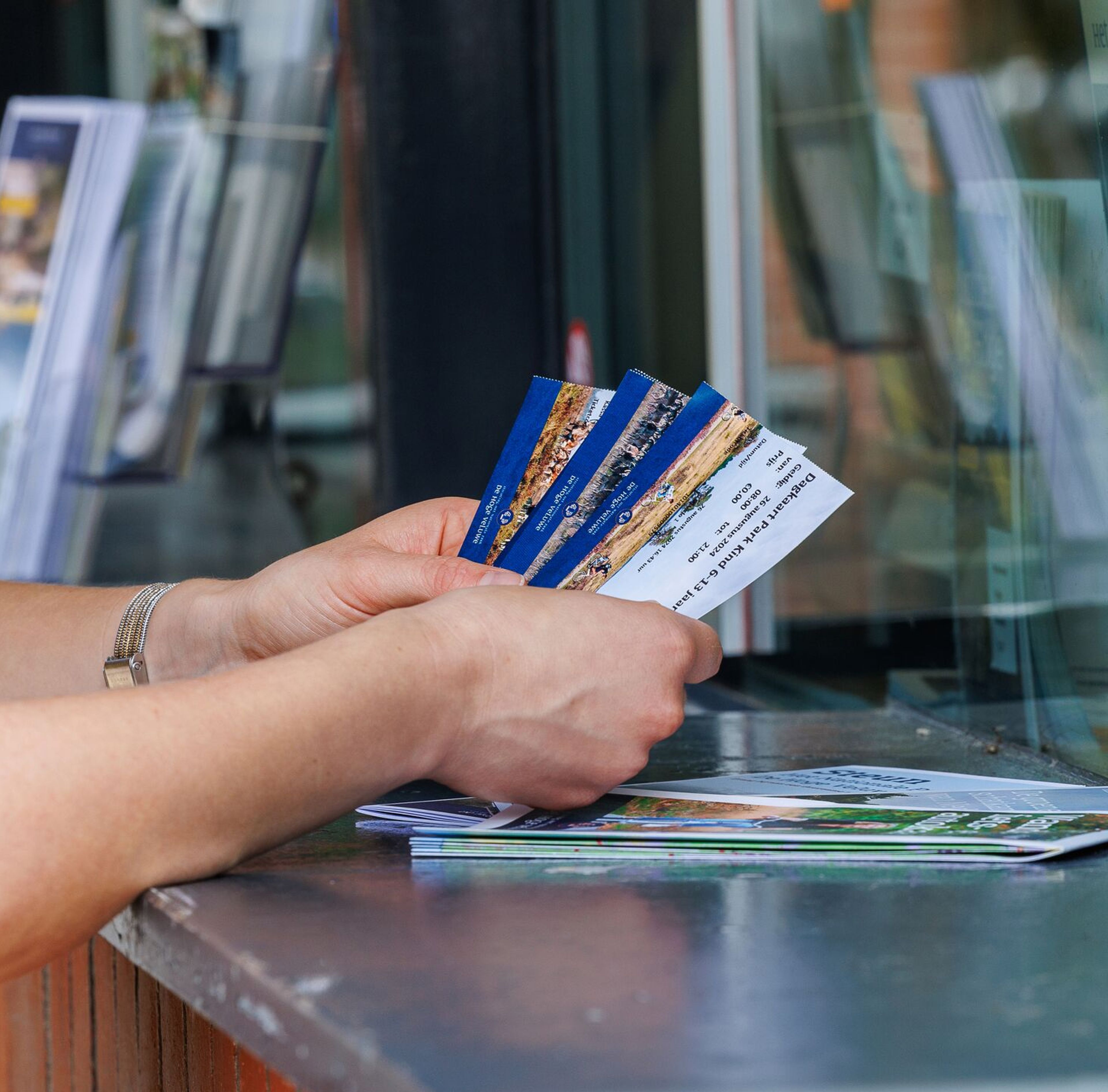 t Foto van een persoon van wie alleen de handen te zien zijn die een ticket ontvangen
