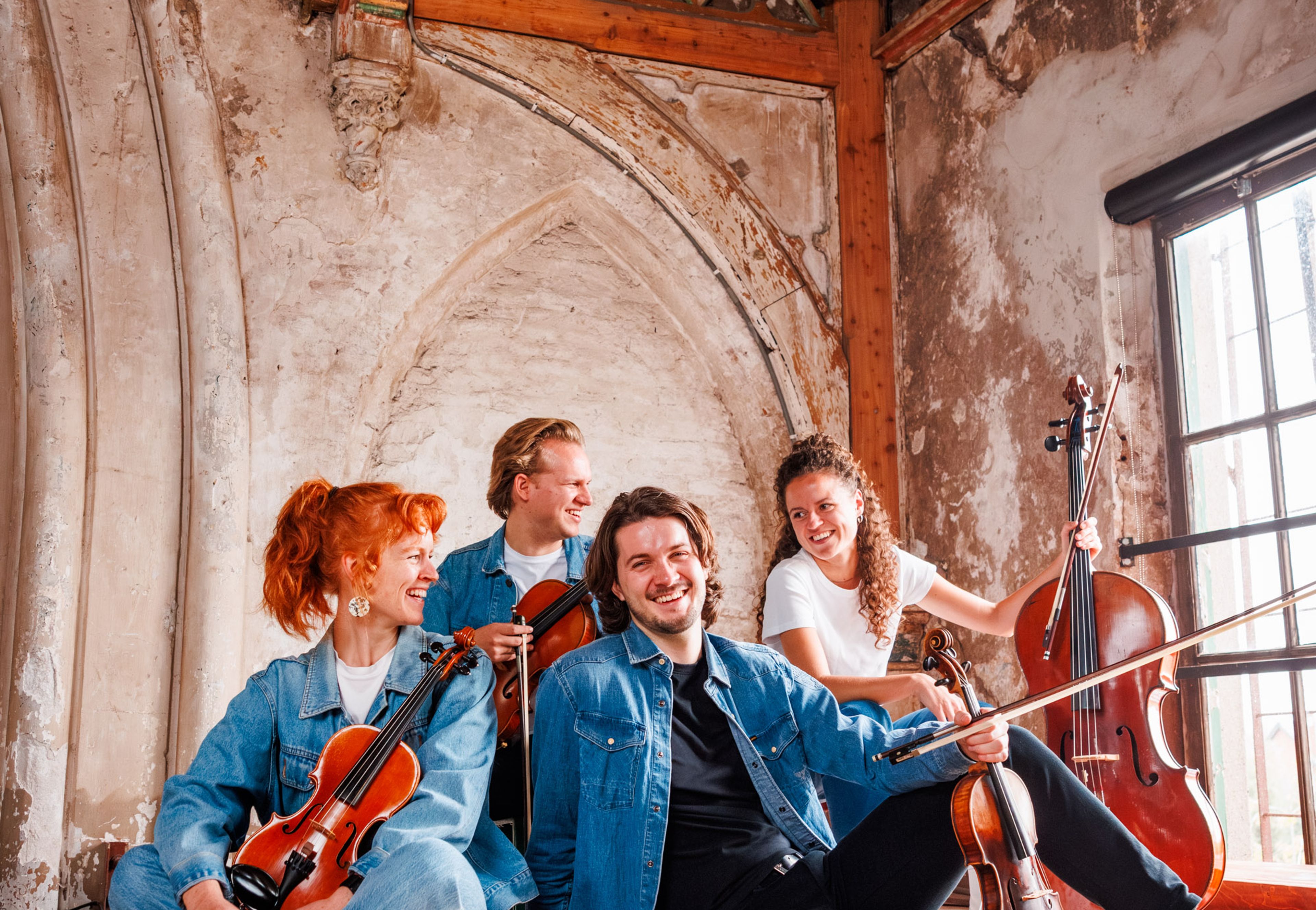 Foto van vier muzikanten, met viool, altviool en cello
