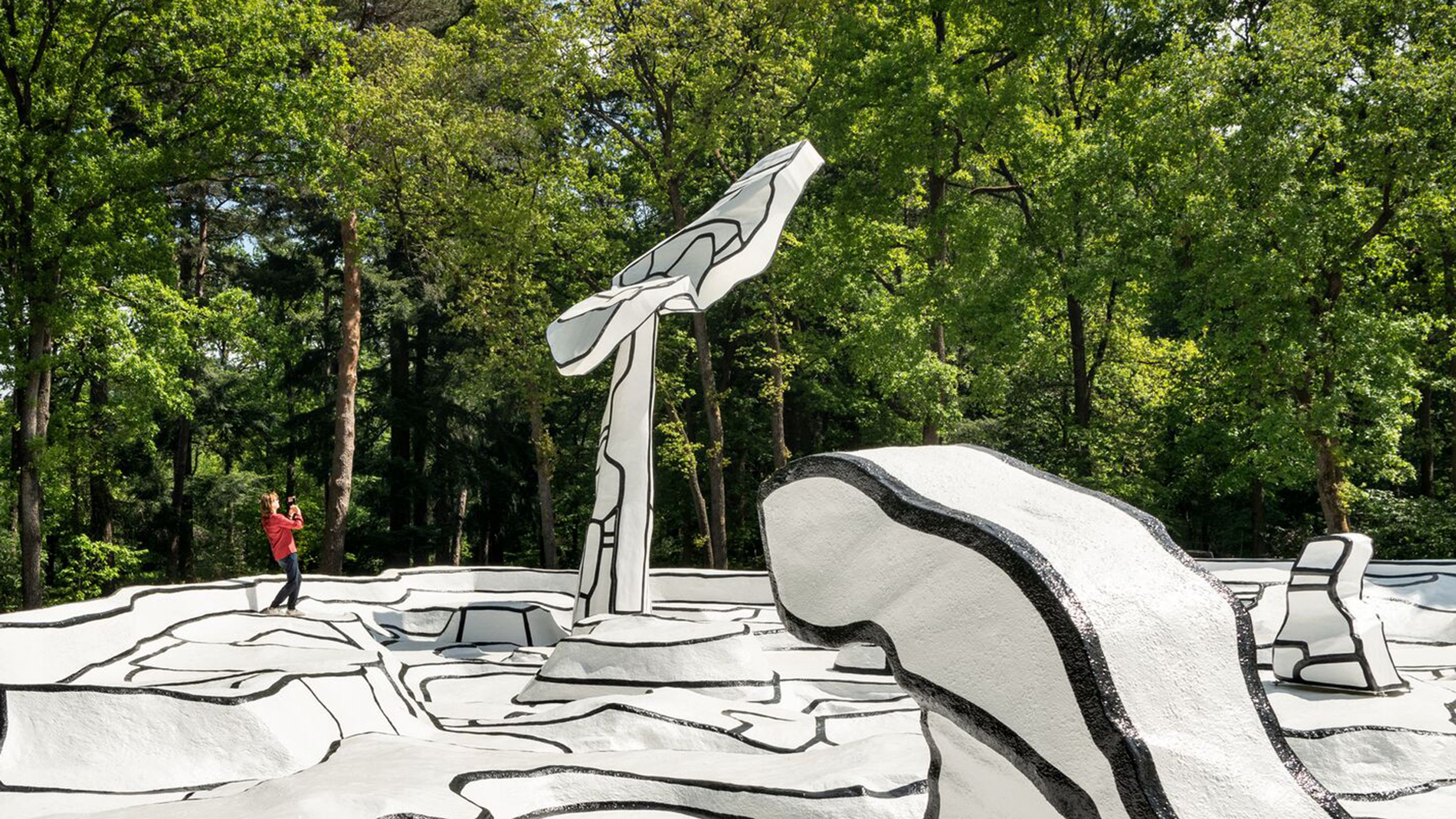 Jean Dubuffet, Jardin d’émail, 1974 Persoon staat op wit kunstwerk van Jean Dubuffet Jardin d’émail en maakt een foto.