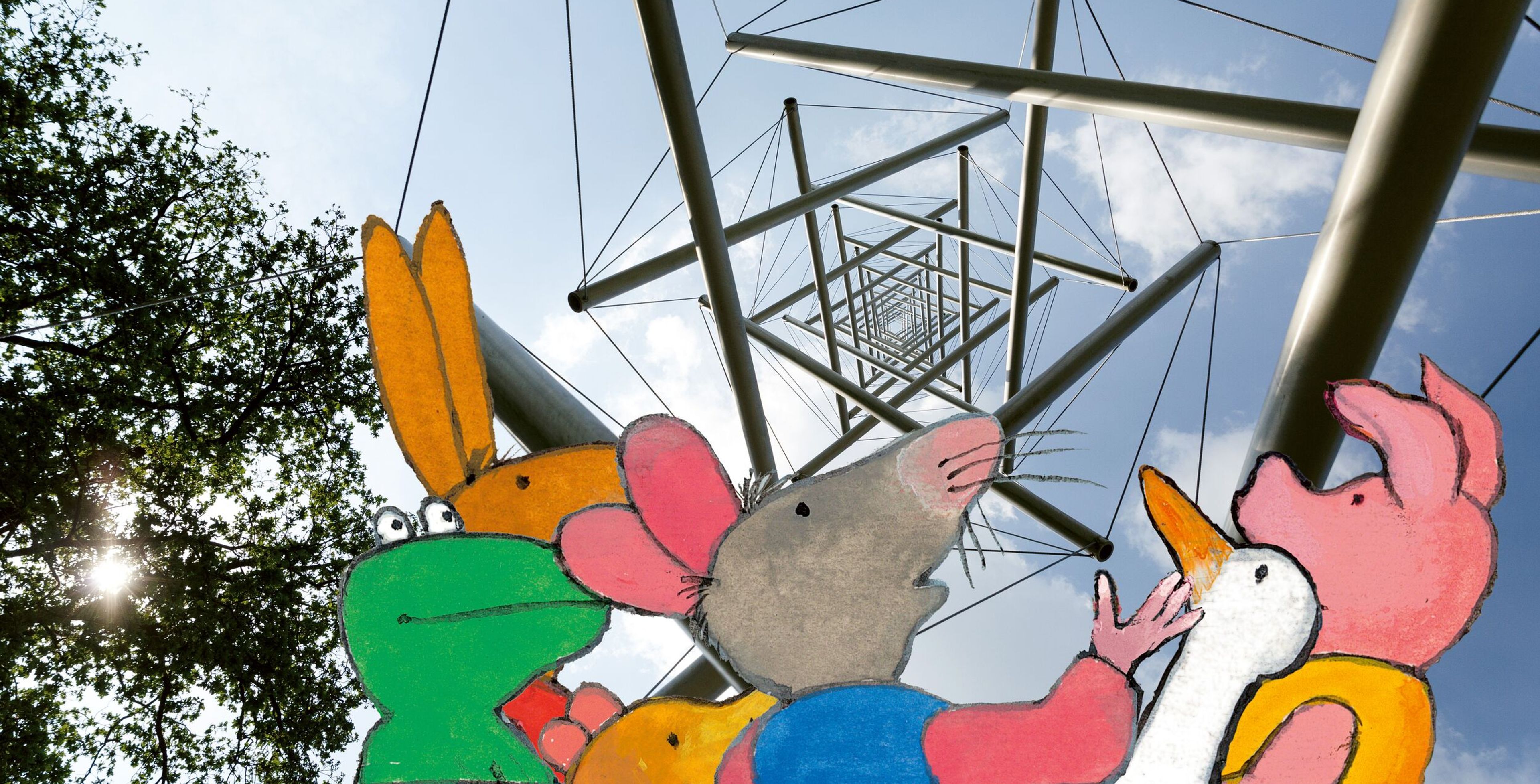 Kikker en zijn vriendjes kijken omhoog naar een stalen kunstwerk in de lucht