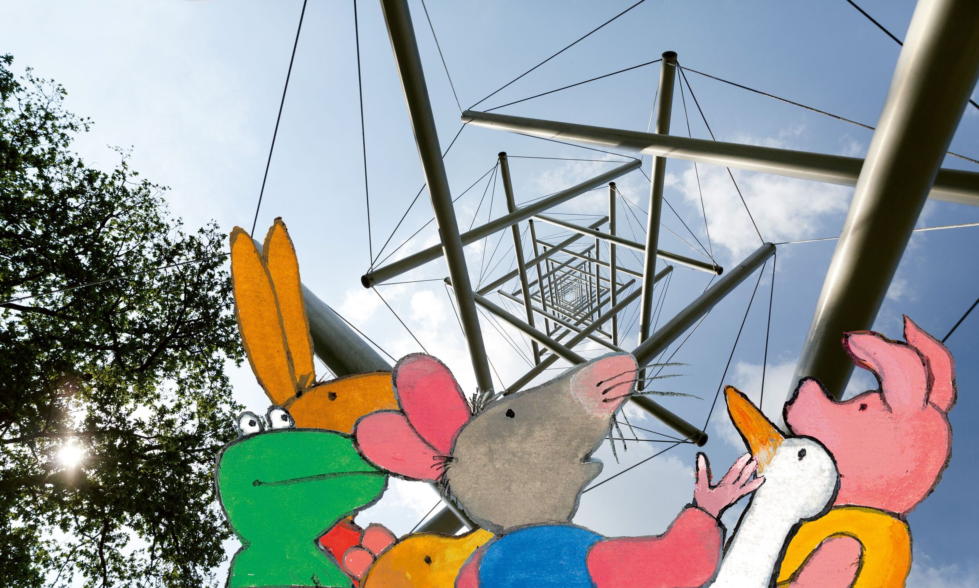Kikker en zijn vriendjes kijken omhoog naar een stalen kunstwerk in de lucht