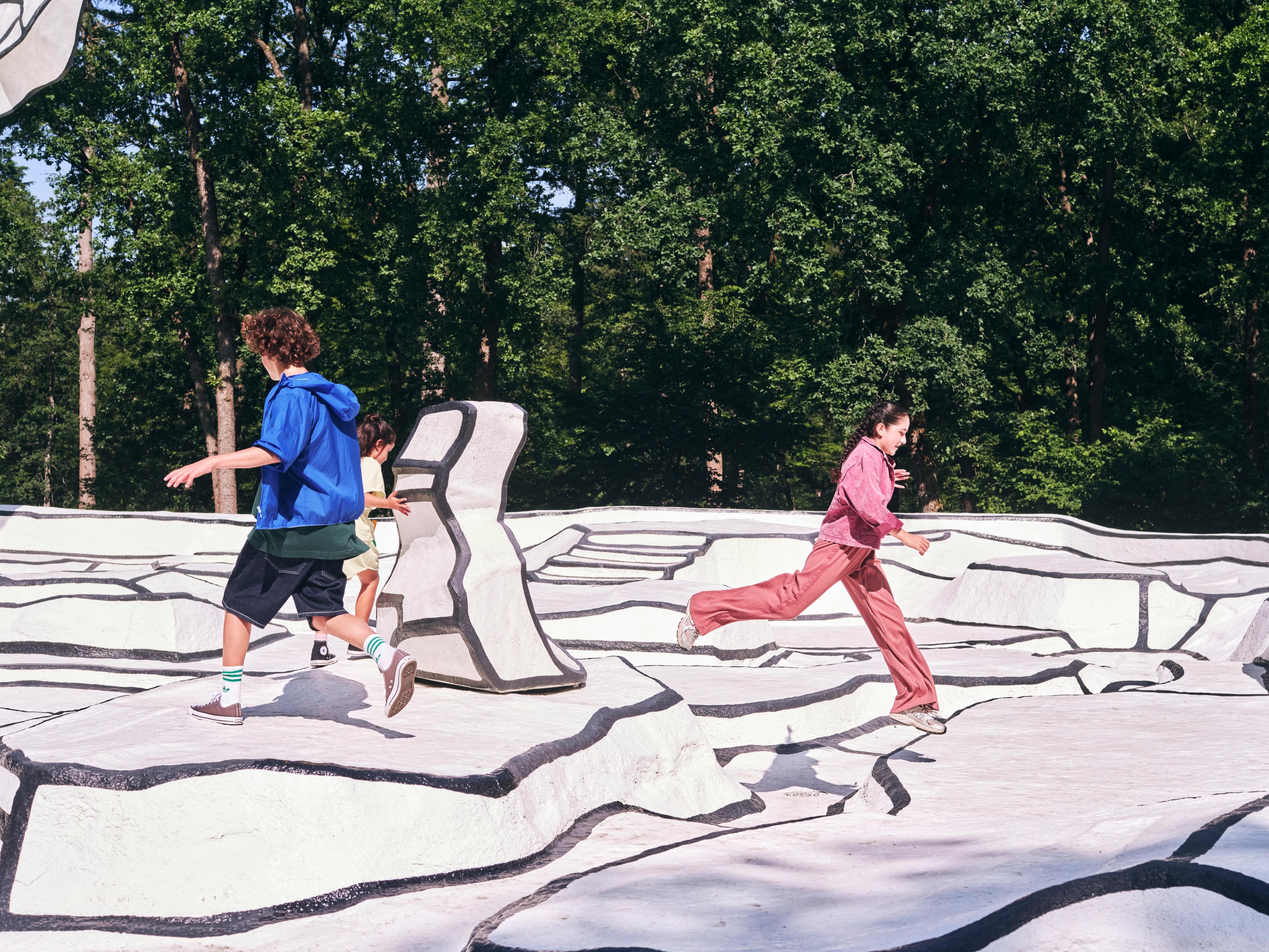 Jean Dubuffet, _Jardin d'émail_, 1974 Twee kinderen spelen op het kunstwerk 'Jardin d'email', een zwart-witte ondergrond in een bos