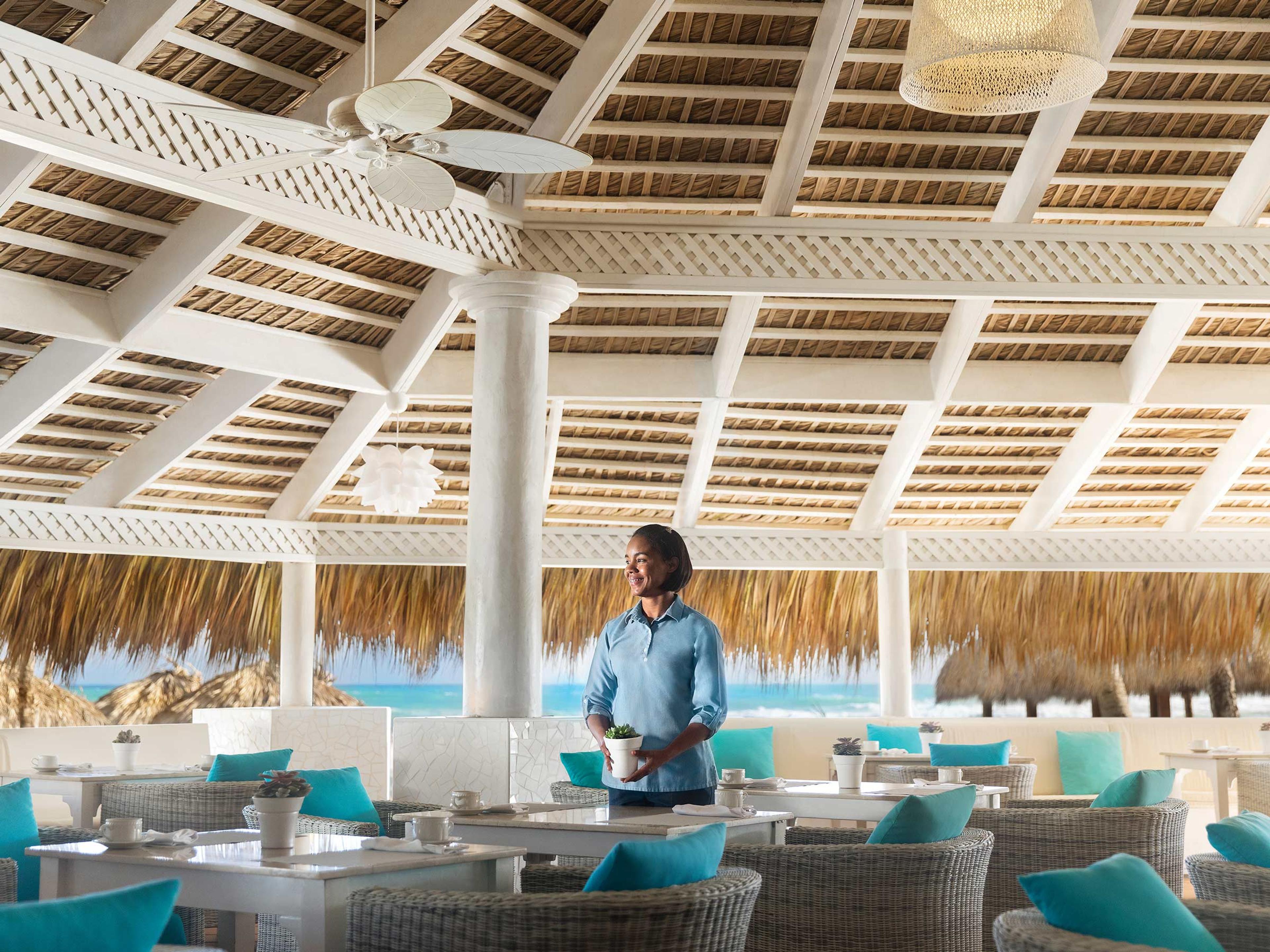 La salle de The Lobster House, sous un toit de chaume, au bord de la plage