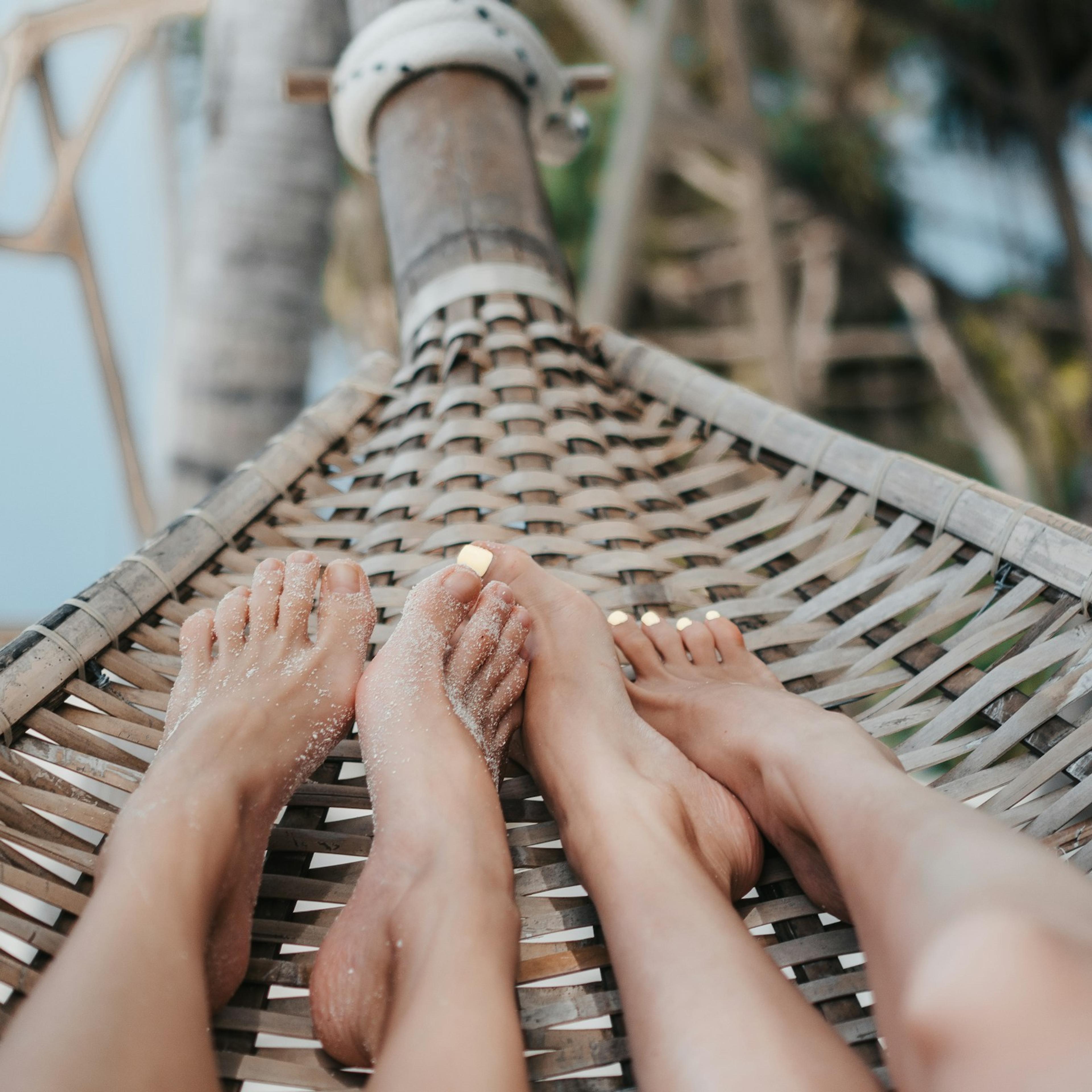 Deux paires de pieds dans un hamac, au bord de la plage