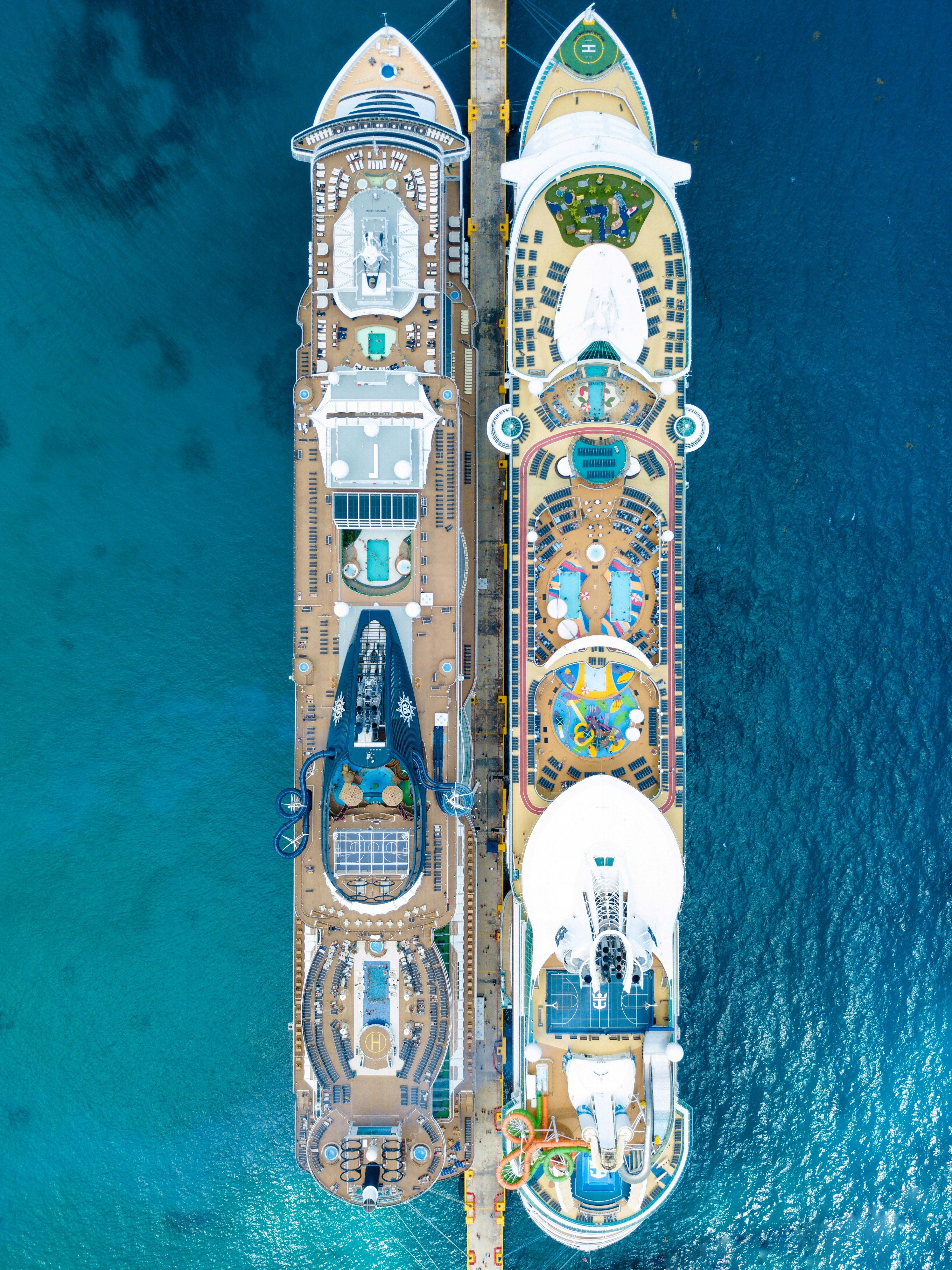Deux navires de croisière amarrés côte à côte, vus du ciel, sur une eau turquoise