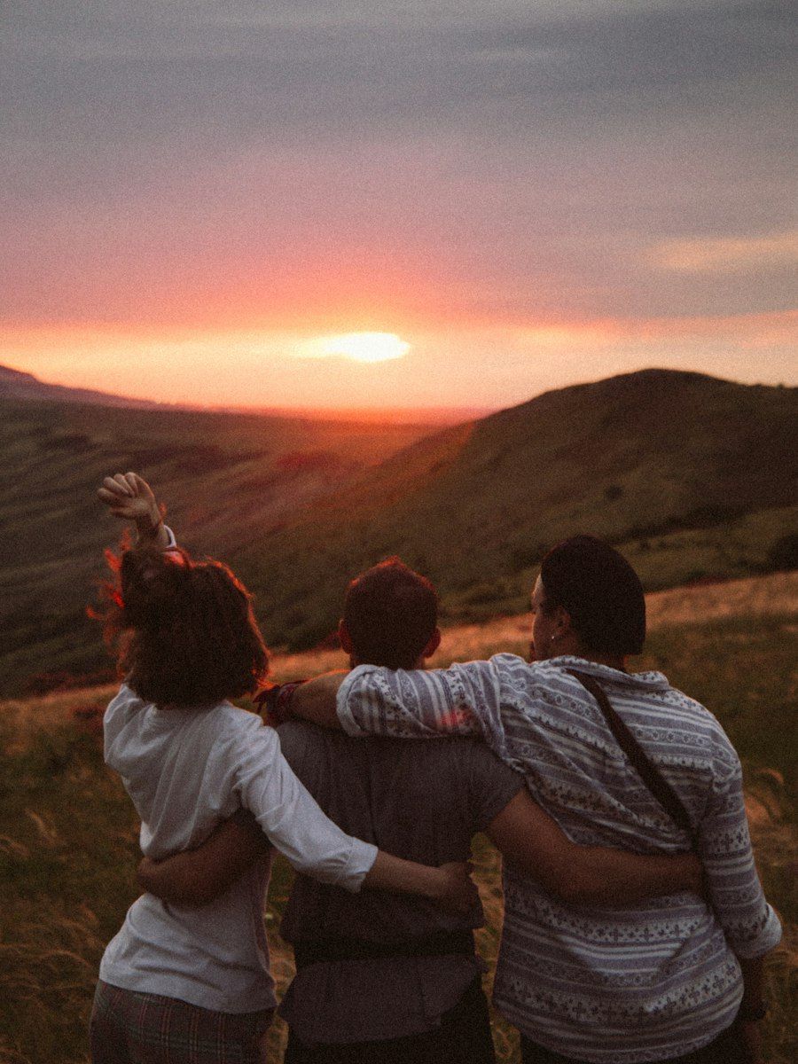 A group of friends arm in arm at sunset