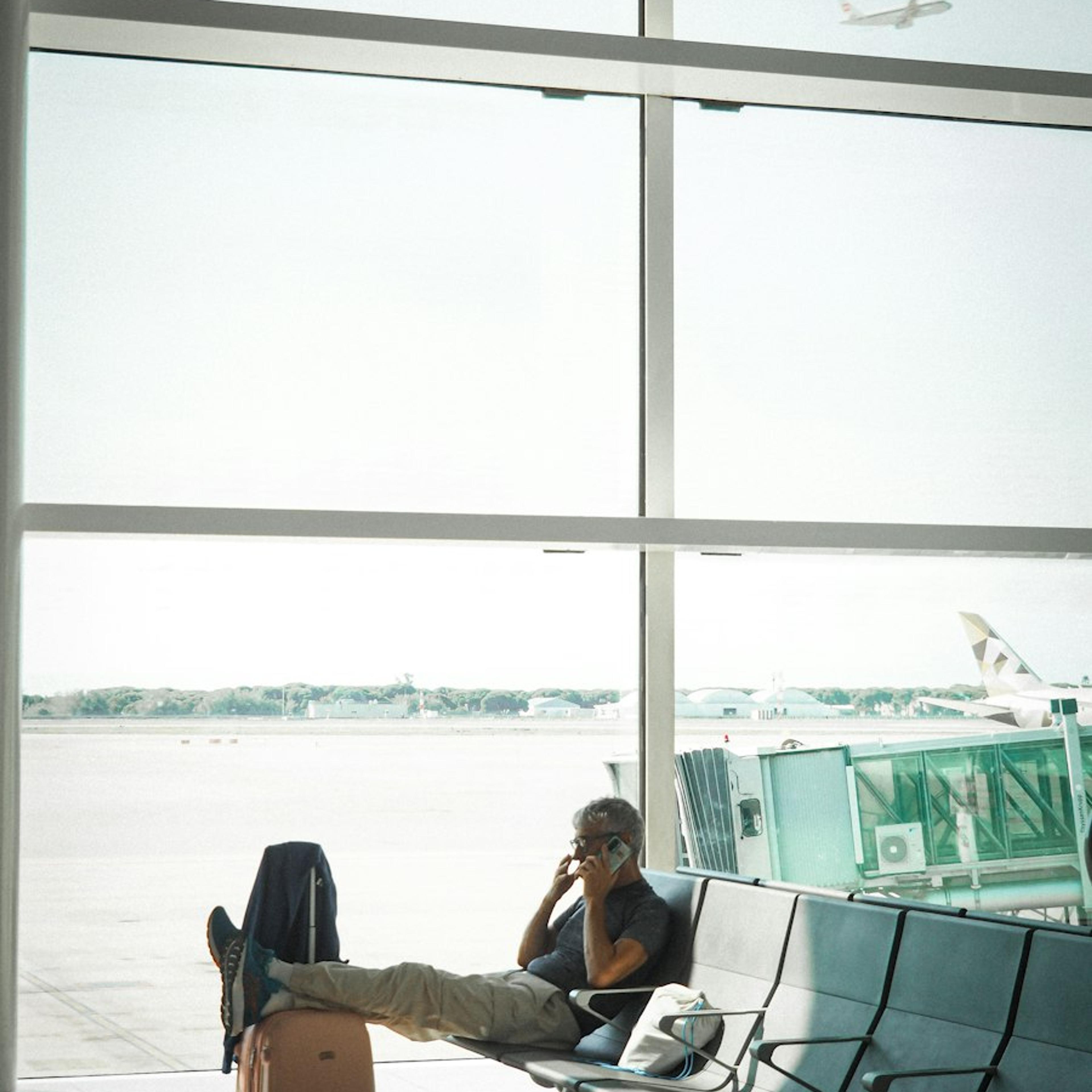 A business traveller working at the airport, by the runway