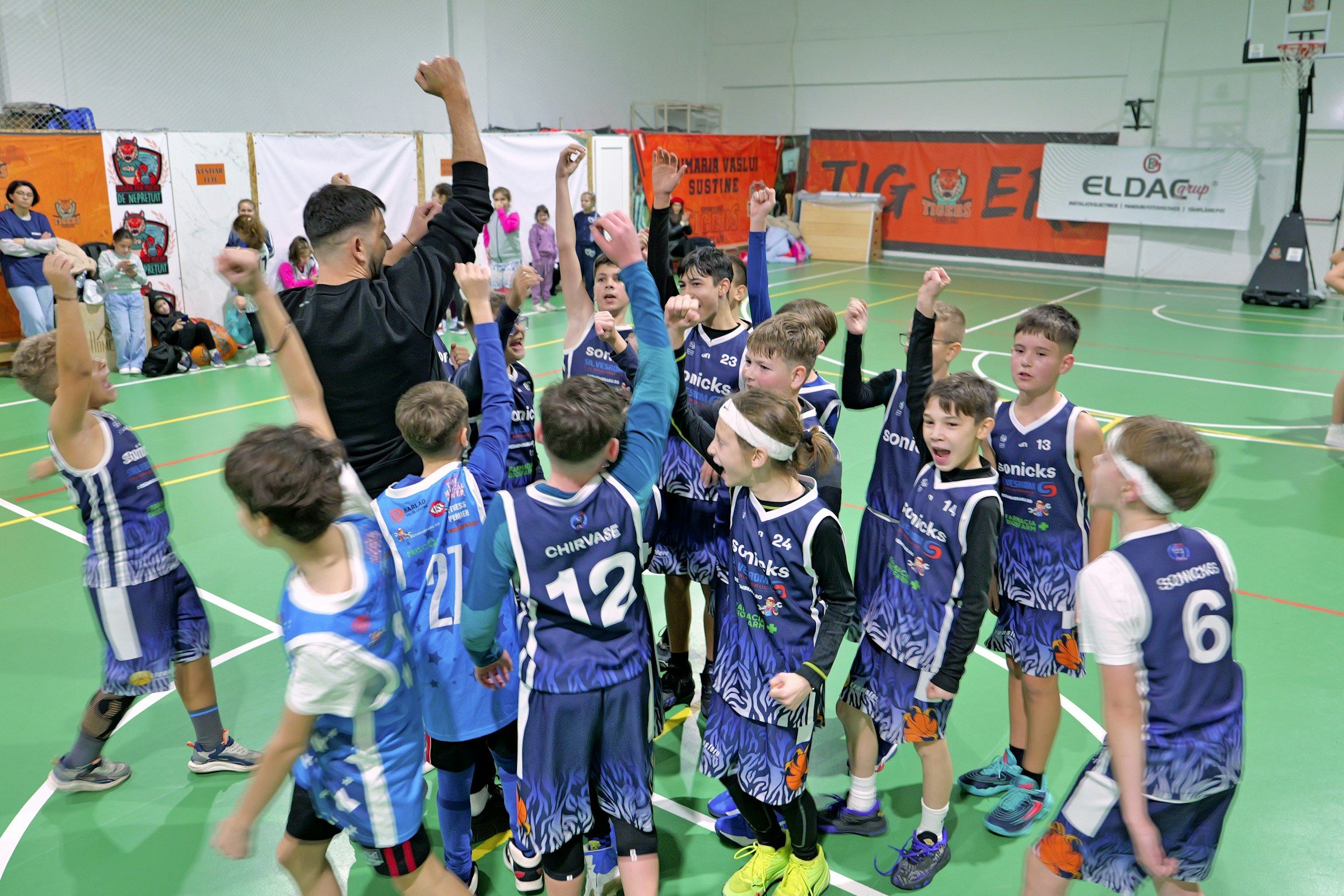 A children's basketball team celebrating on the court