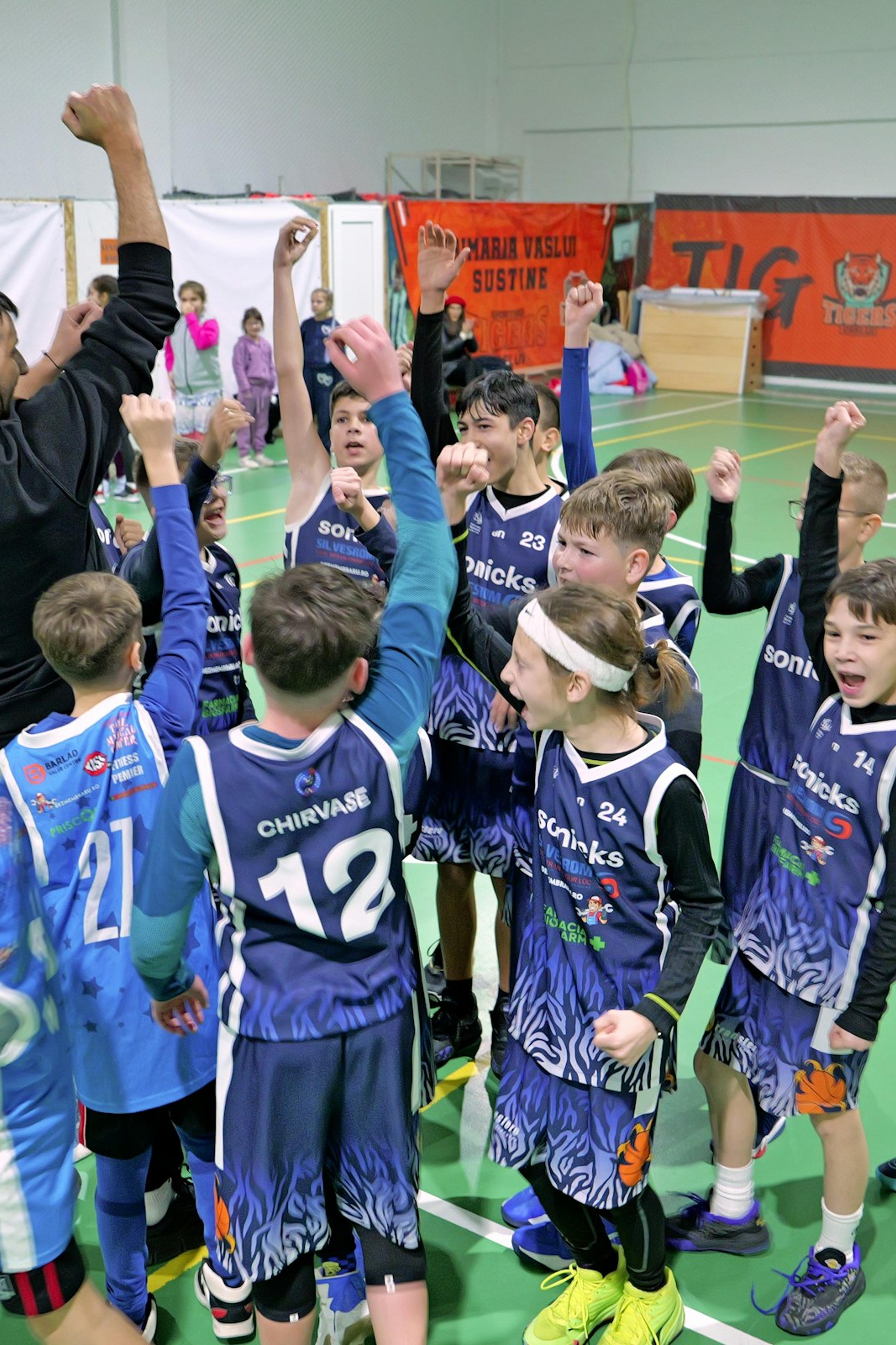 A children's basketball team celebrating on the court