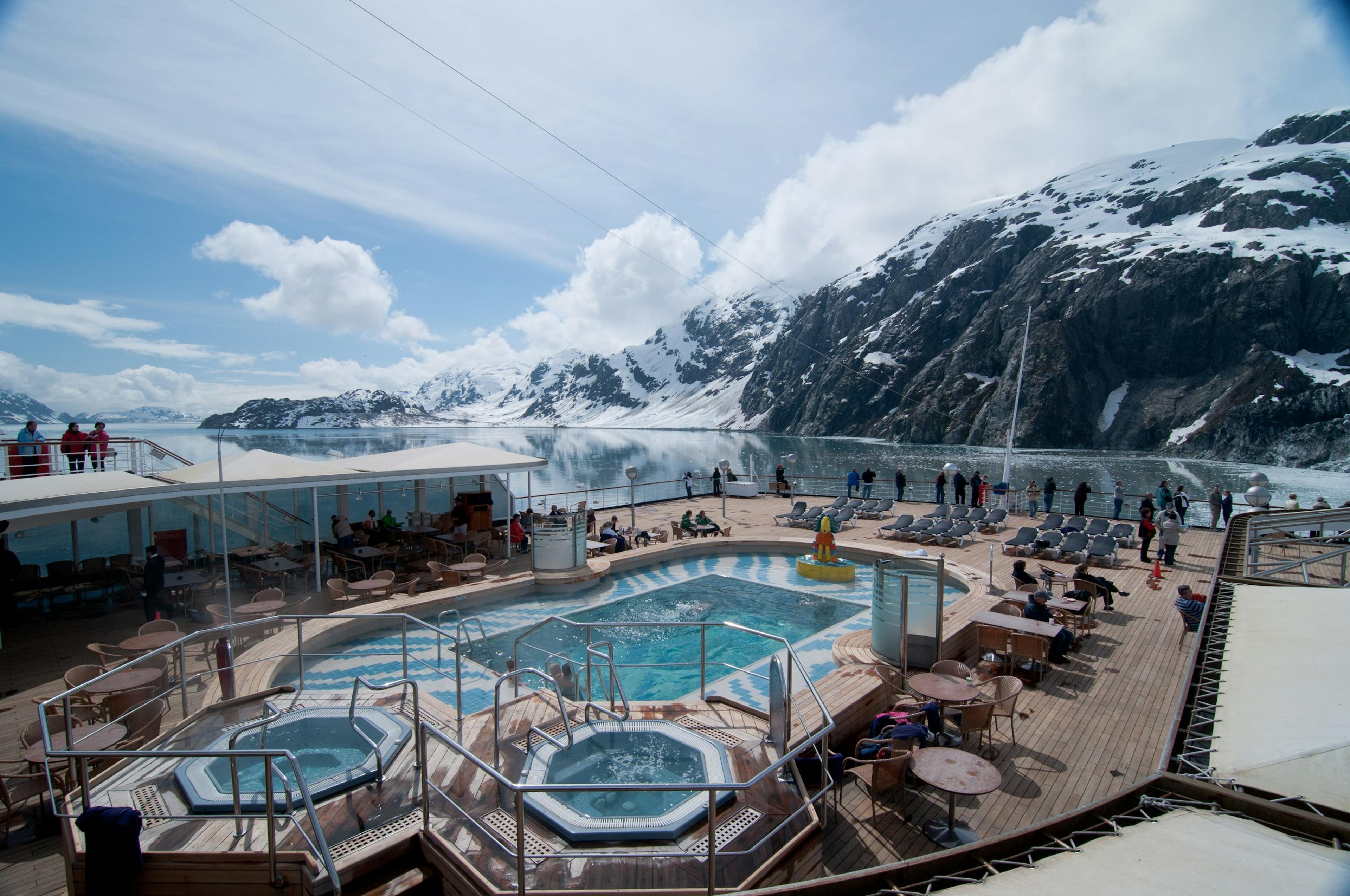 A glacier and snowy mountains seen from a ship's deck