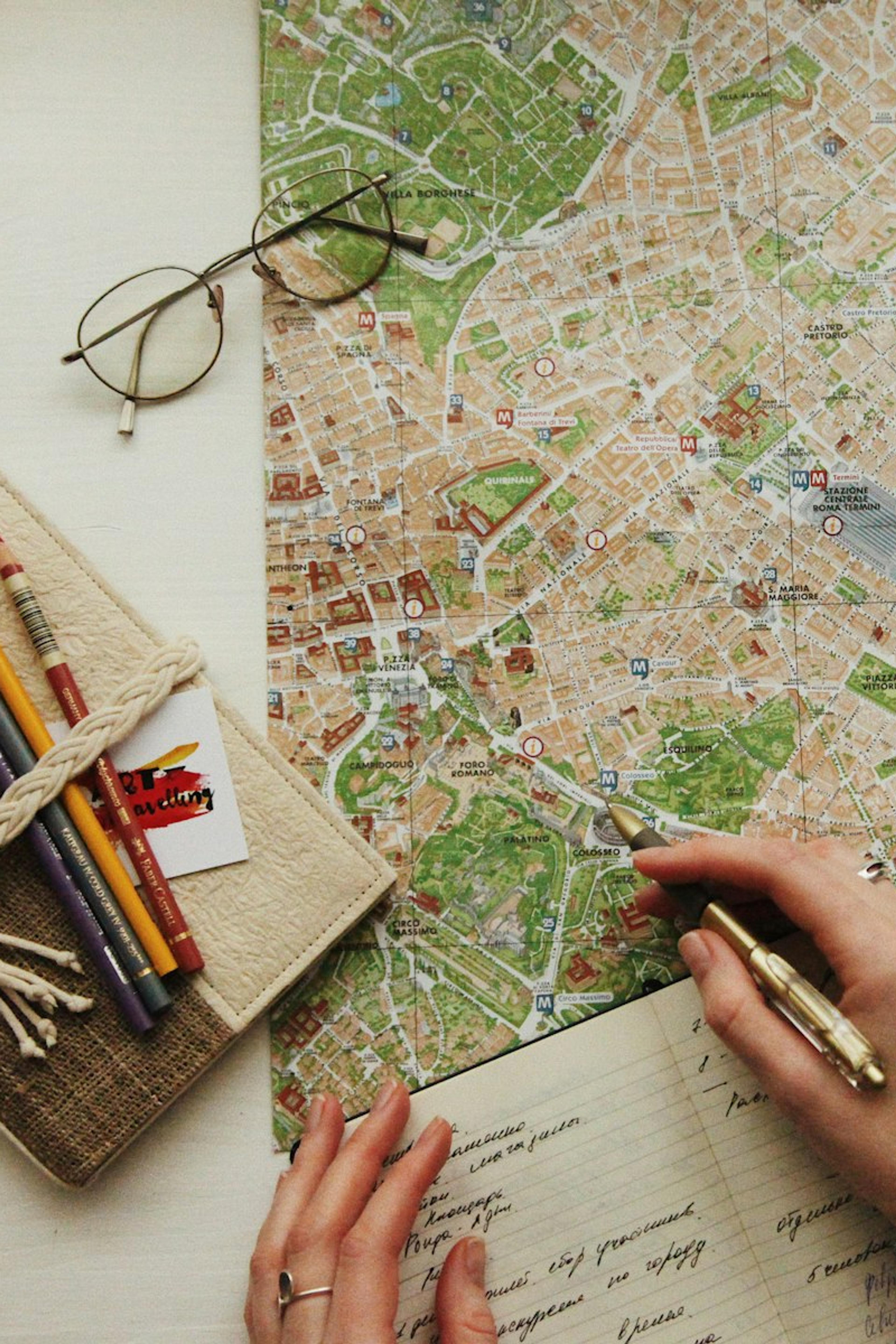 Hands marking an itinerary on a map