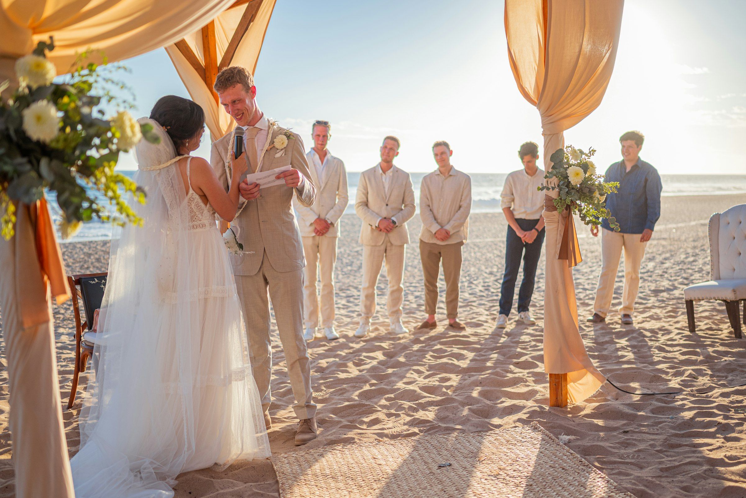 A wedding ceremony on a beach at sunset