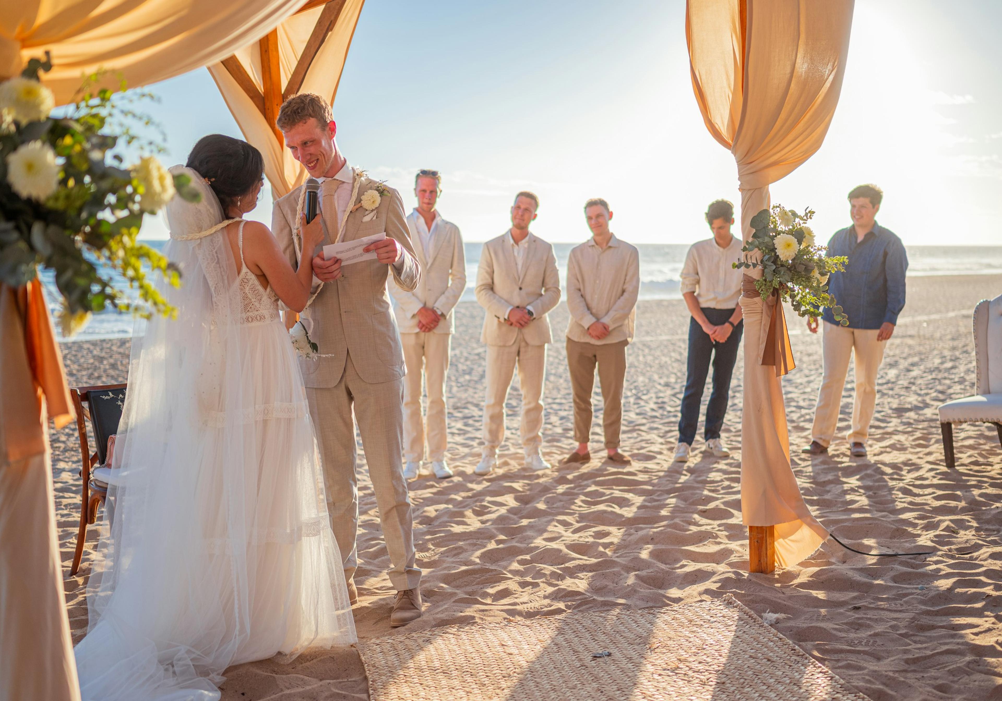 A wedding ceremony on a beach at sunset