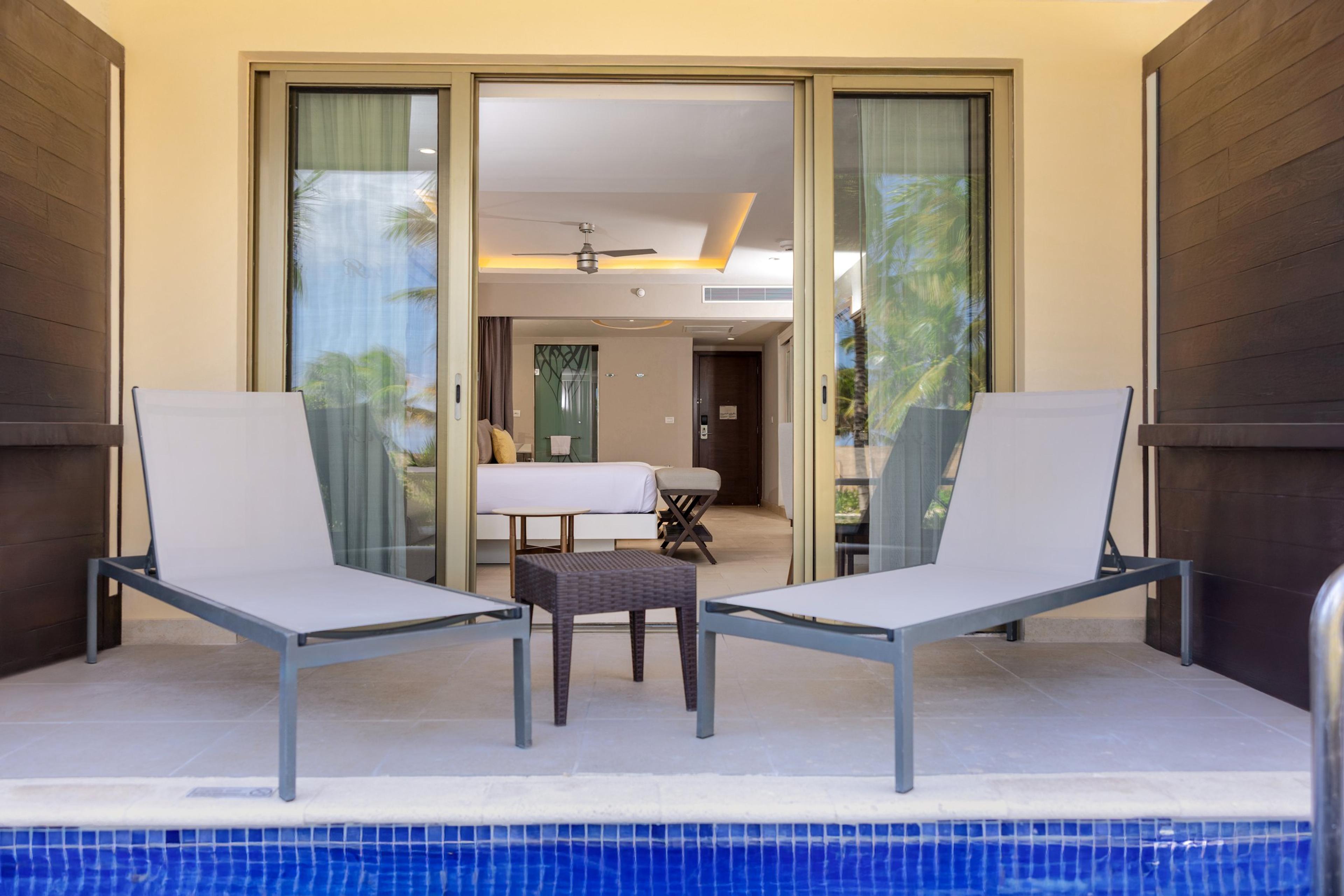La terrasse d'une junior suite du Royalton Riviera Cancun, avec ses chaises longues et un accès direct à la piscine