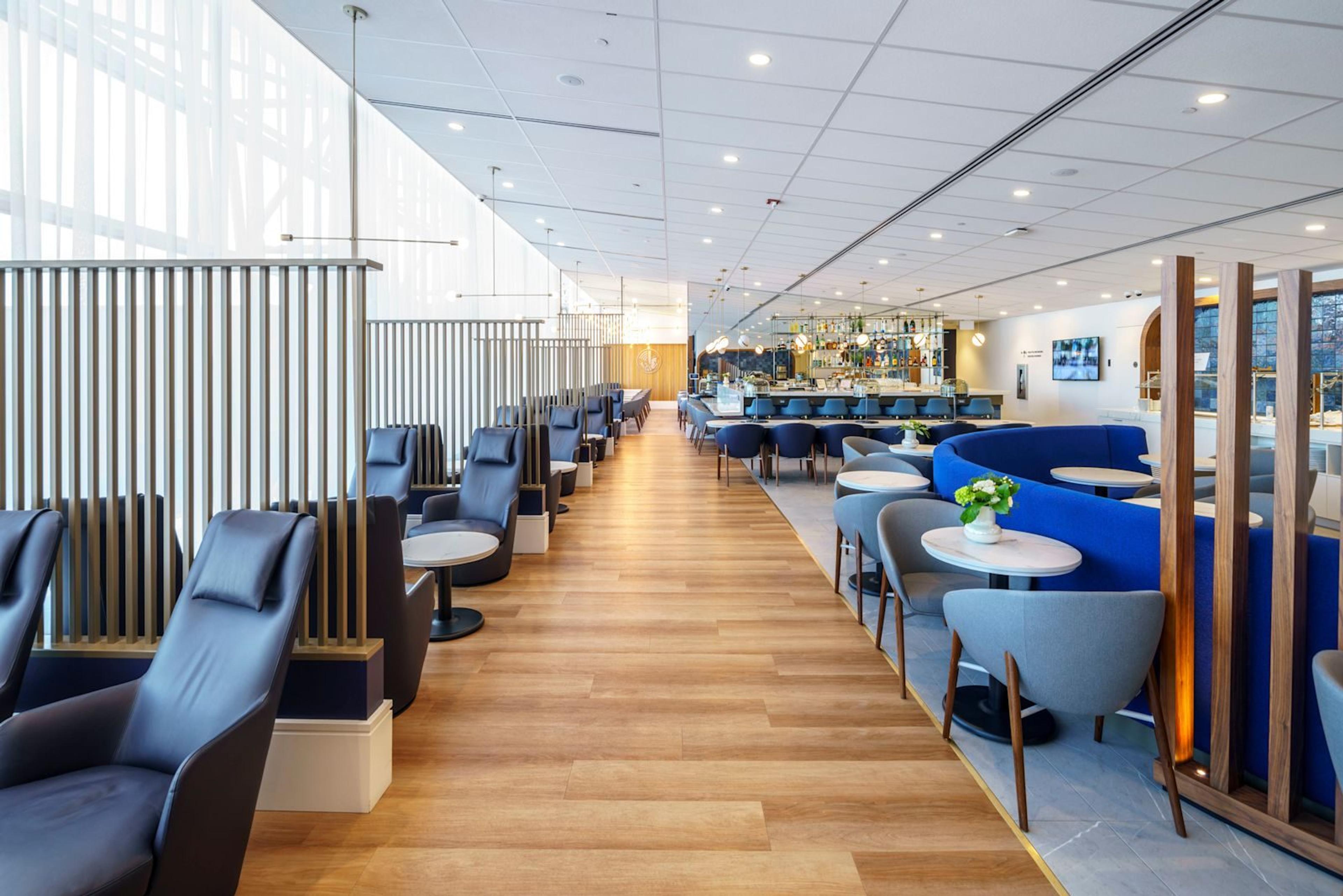 Une allée de fauteuils bleus le long des fenêtres du salon Air France