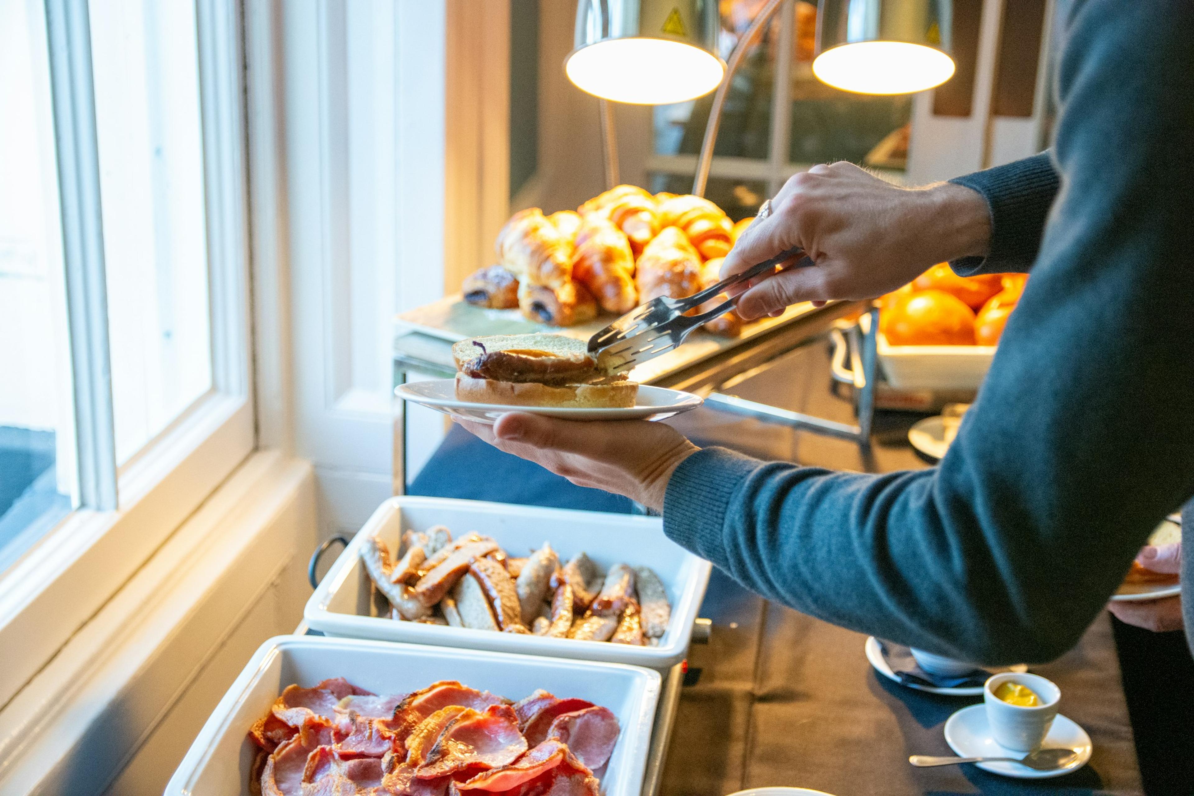 A hand serving itself at a hotel buffet