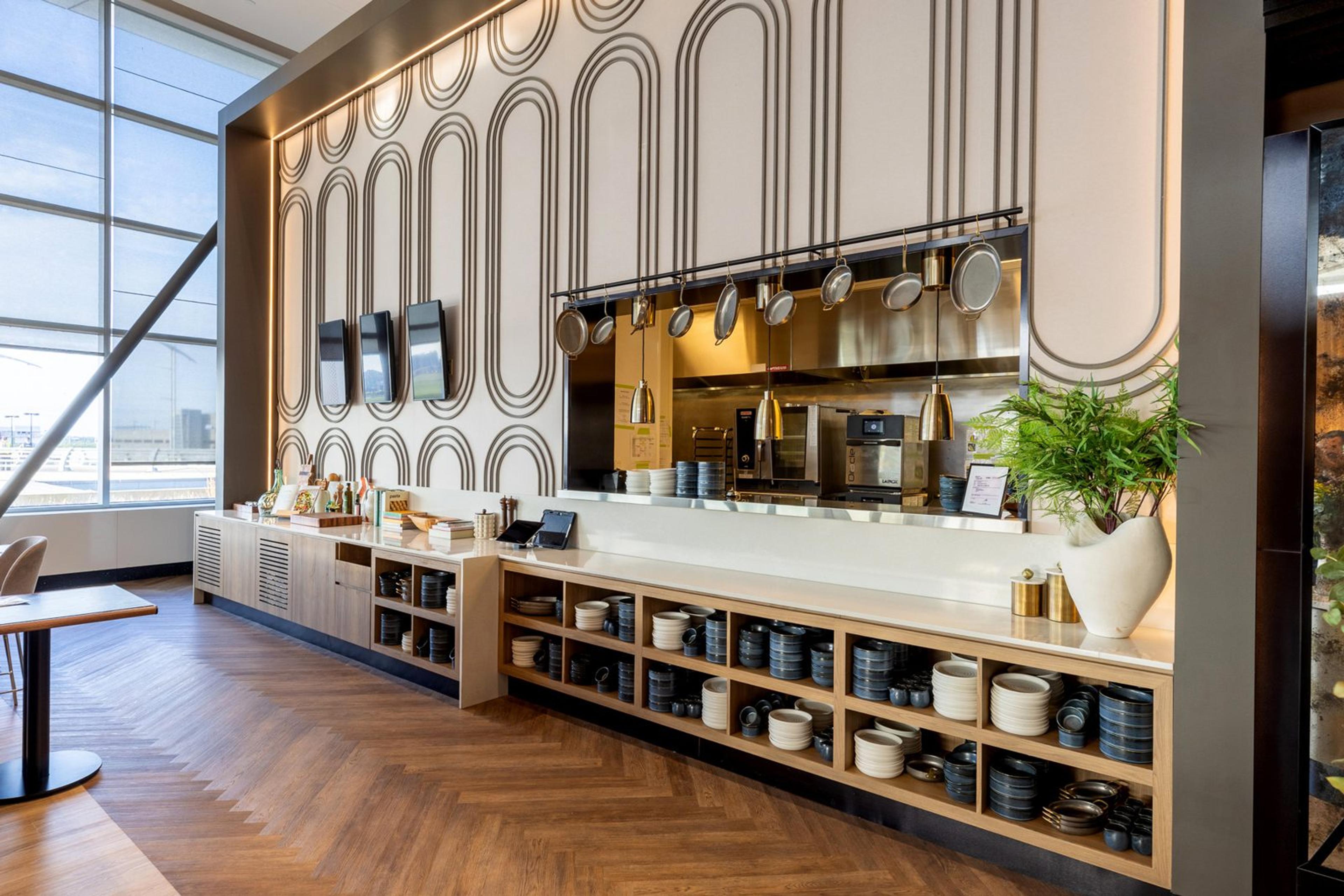 La cuisine ouverte du salon Aspire, avec sa vaisselle et ses casseroles suspendues