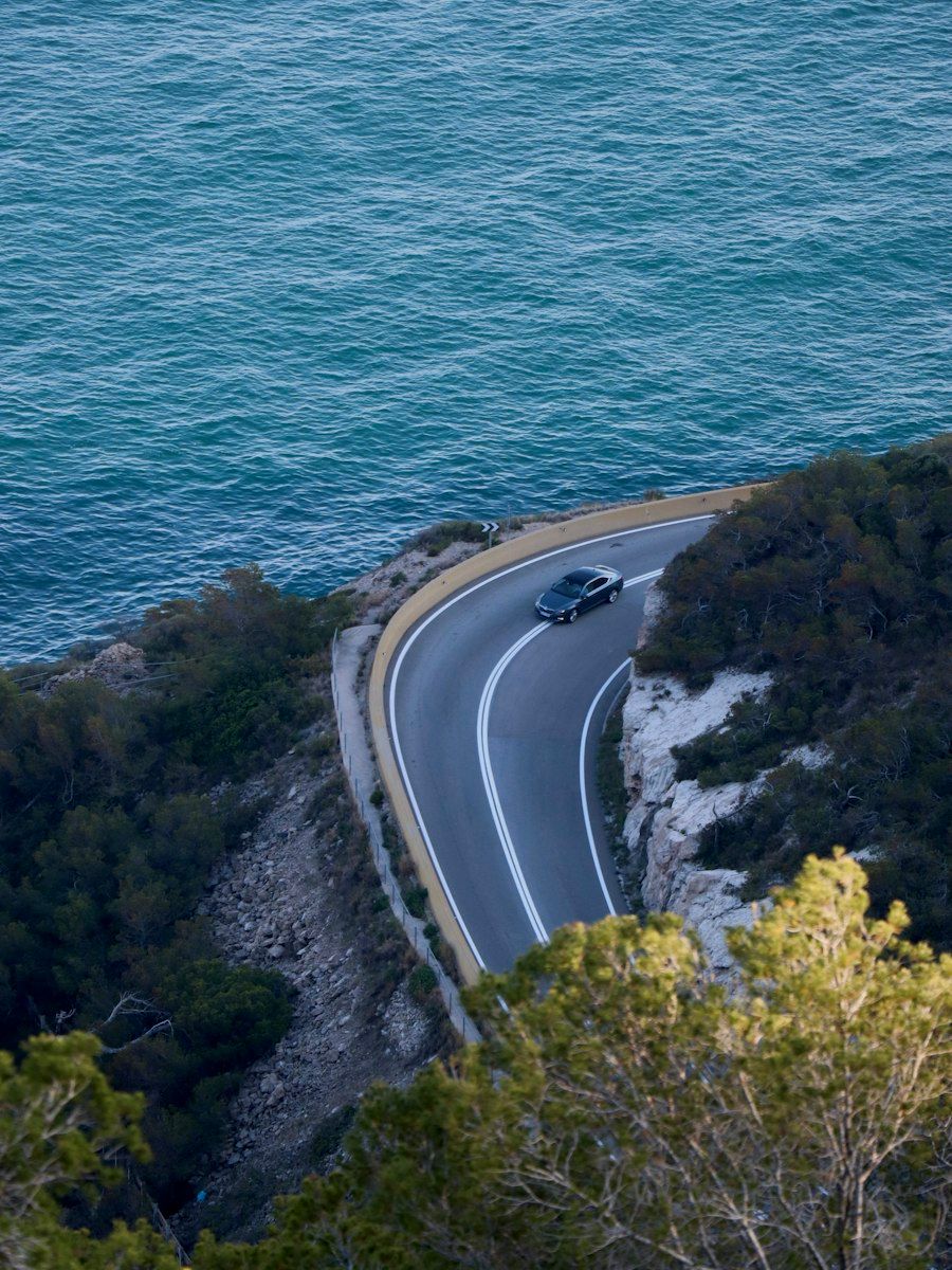 A car on a coastal road, seen from above