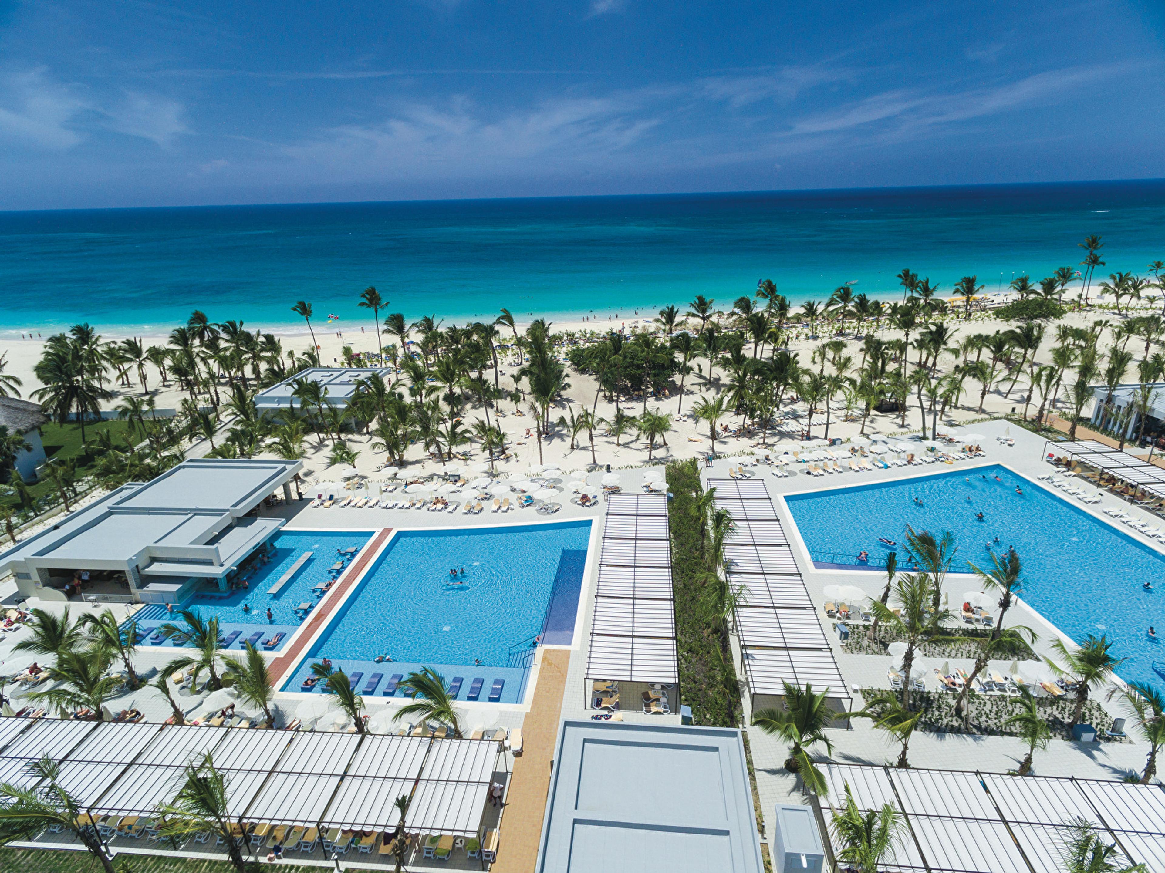 The pools of the Riu Republica, surrounded by palm trees, facing the sea