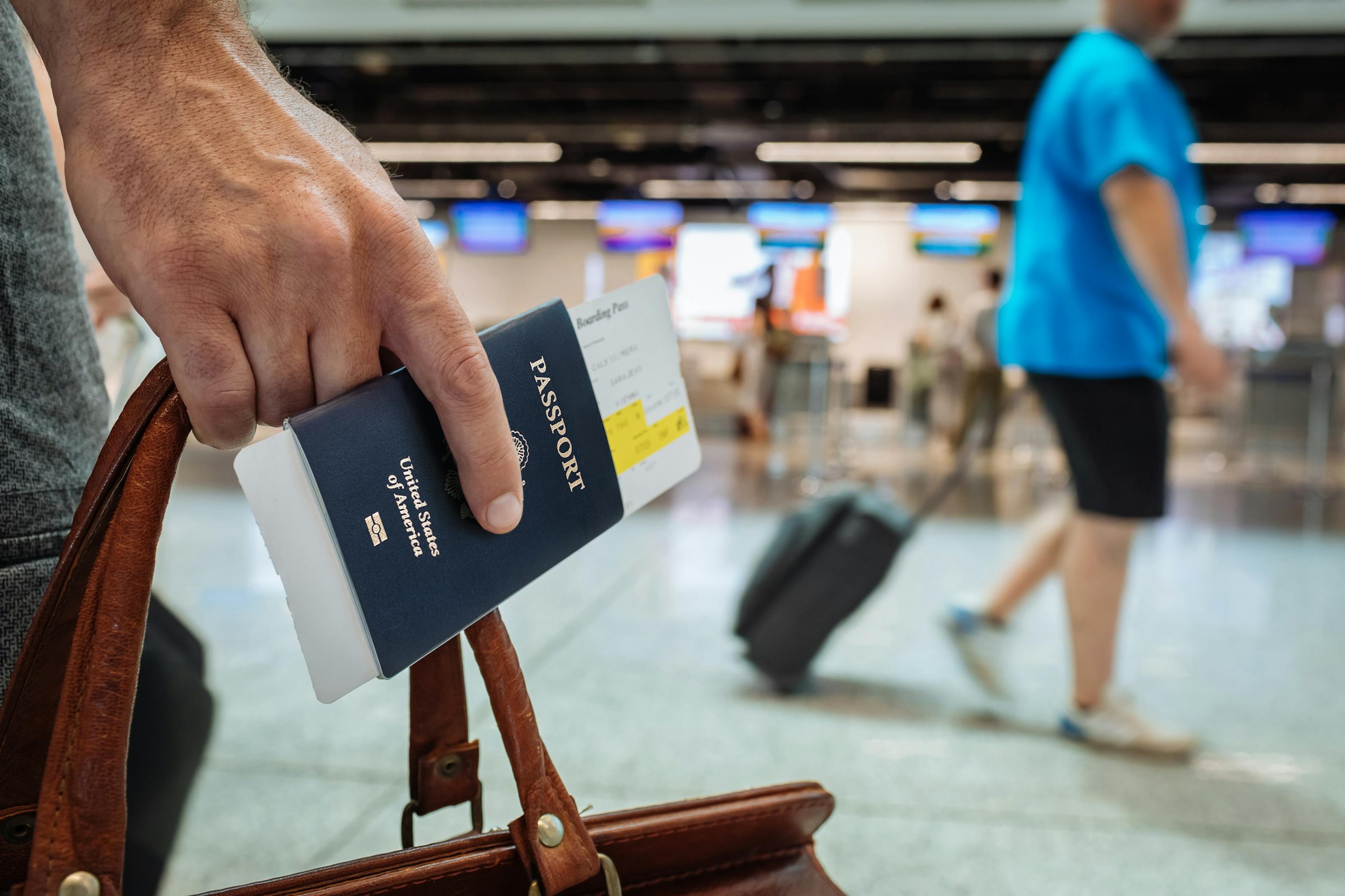 A traveller holding a passport and boarding pass