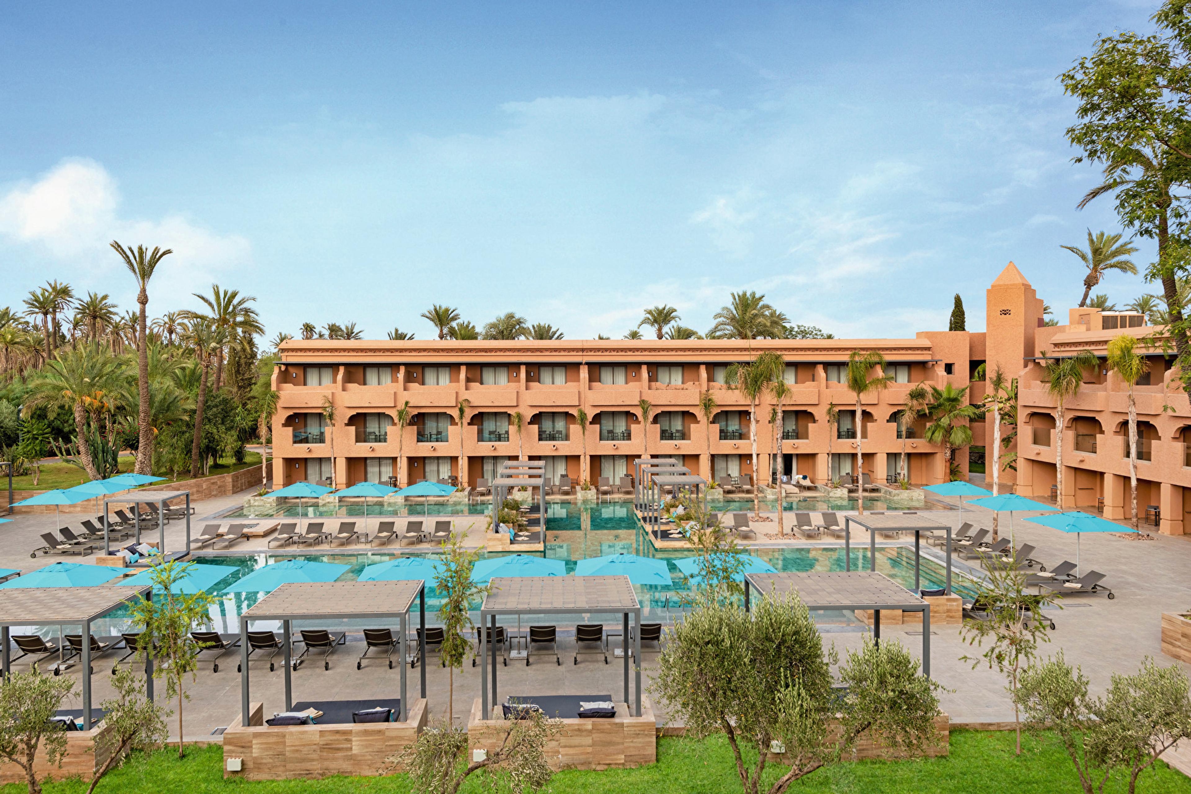 The pool and ochre buildings of the Riu Tikida Garden, in Marrakech